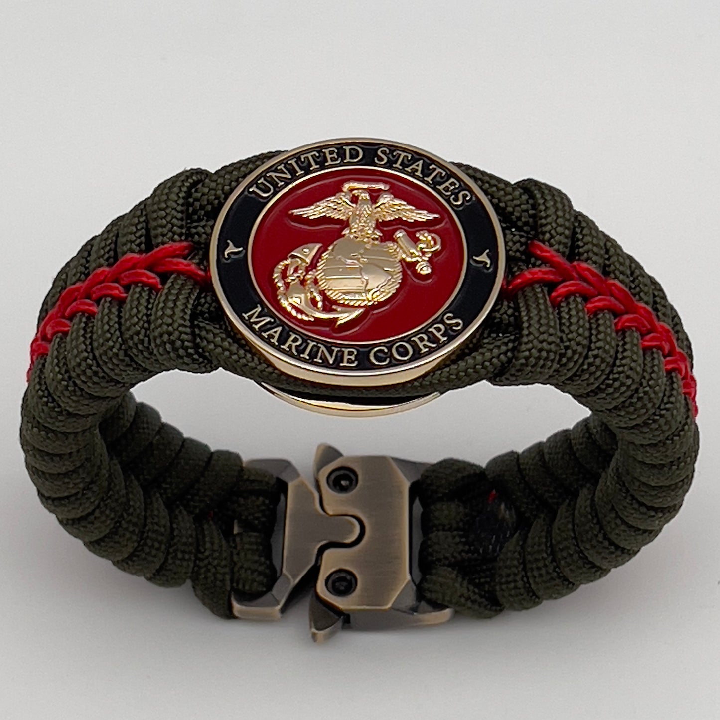 Thick, semi-rigid and comfortable braided United States Marine Corps bracelet featuring a 24K gold plated USMC officer Eagle Globe and Anchor medallion, a gold Cobra style tactical buckle and woven with olive drab 550 paracord and Imperial Red micro cord.