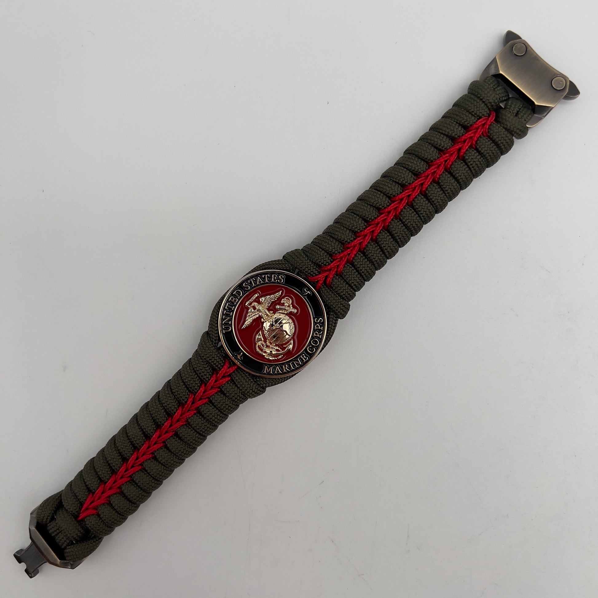 Thick, semi-rigid and comfortable braided United States Marine Corps bracelet featuring a 24K gold plated USMC officer Eagle Globe and Anchor medallion, a gold Cobra style tactical buckle and woven with olive drab 550 paracord and Imperial Red micro cord.