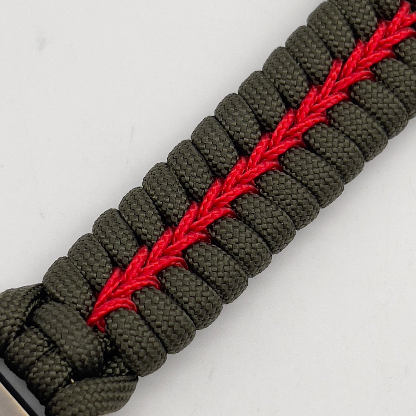 Thick, semi-rigid and comfortable braided United States Marine Corps bracelet featuring a 24K gold plated USMC officer Eagle Globe and Anchor medallion, a gold Cobra style tactical buckle and woven with olive drab 550 paracord and Imperial Red micro cord.