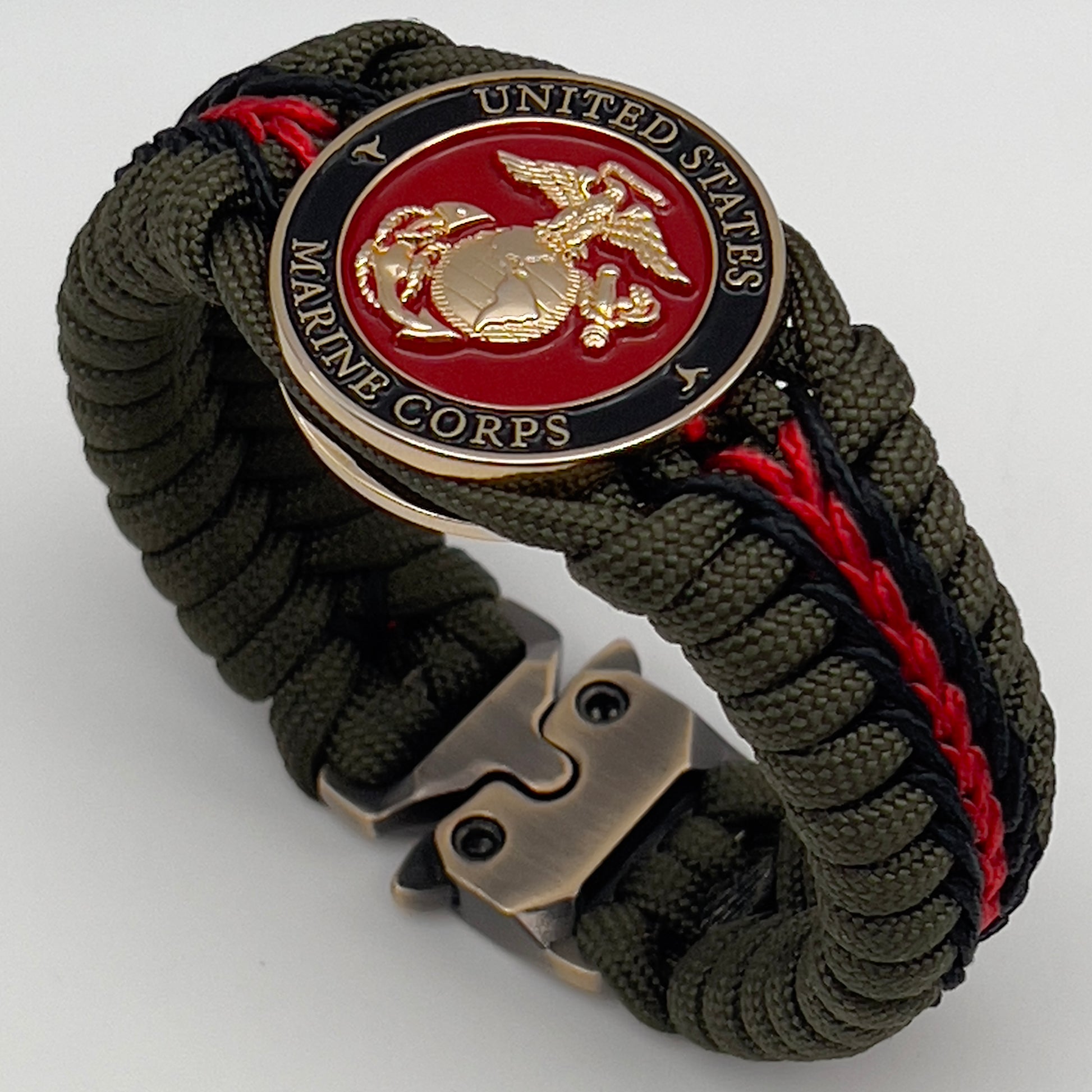 Thick, rigid and comfortable braided United States Marine Corps bracelet featuring a 24K gold plated USMC officer Eagle Globe and Anchor medallion, a gold Cobra style tactical buckle and woven with olive drab 550 paracord and black and Imperial red micro cord.