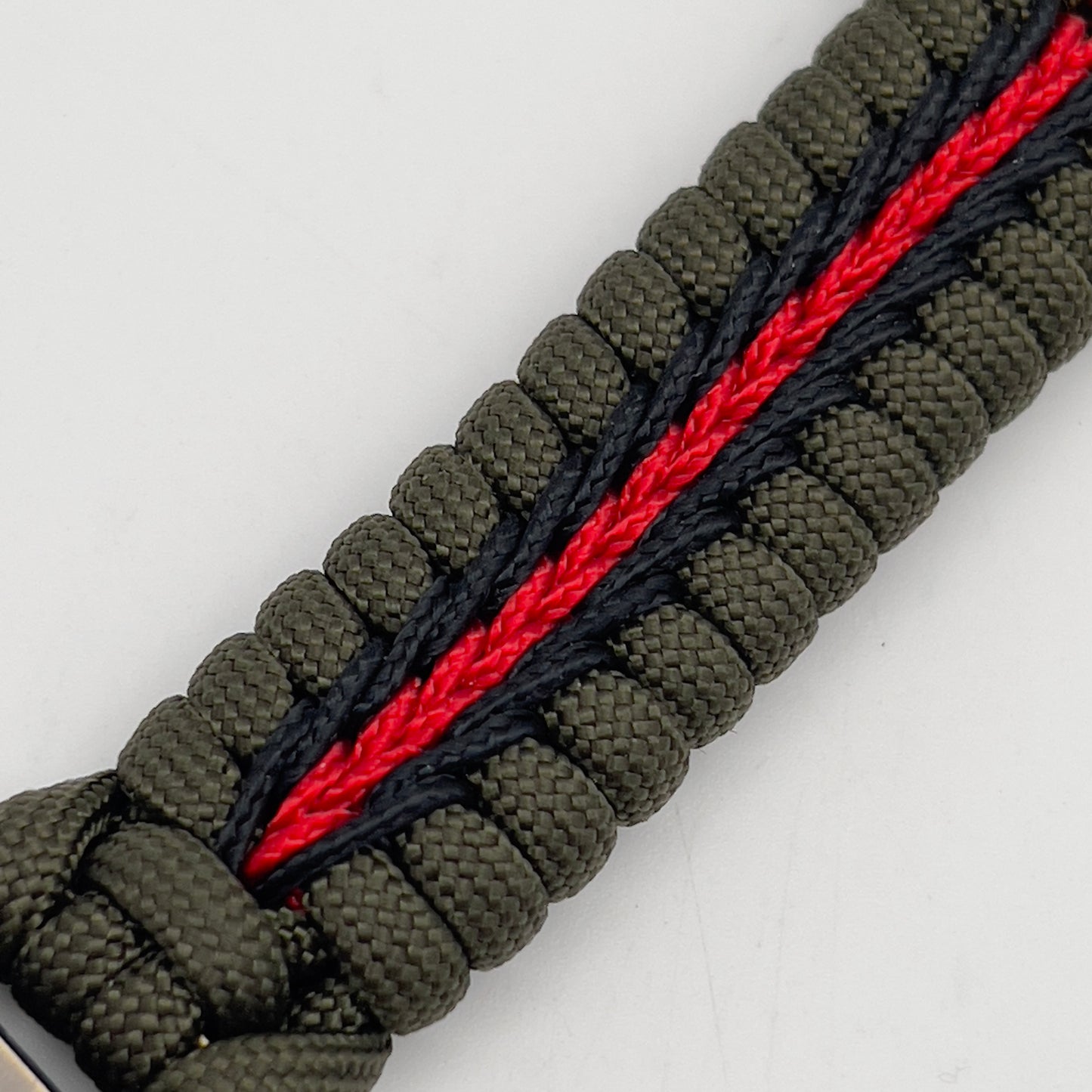 Thick, rigid and comfortable braided United States Marine Corps bracelet featuring a 24K gold plated USMC officer Eagle Globe and Anchor medallion, a gold Cobra style tactical buckle and woven with olive drab 550 paracord and black and Imperial red micro cord.