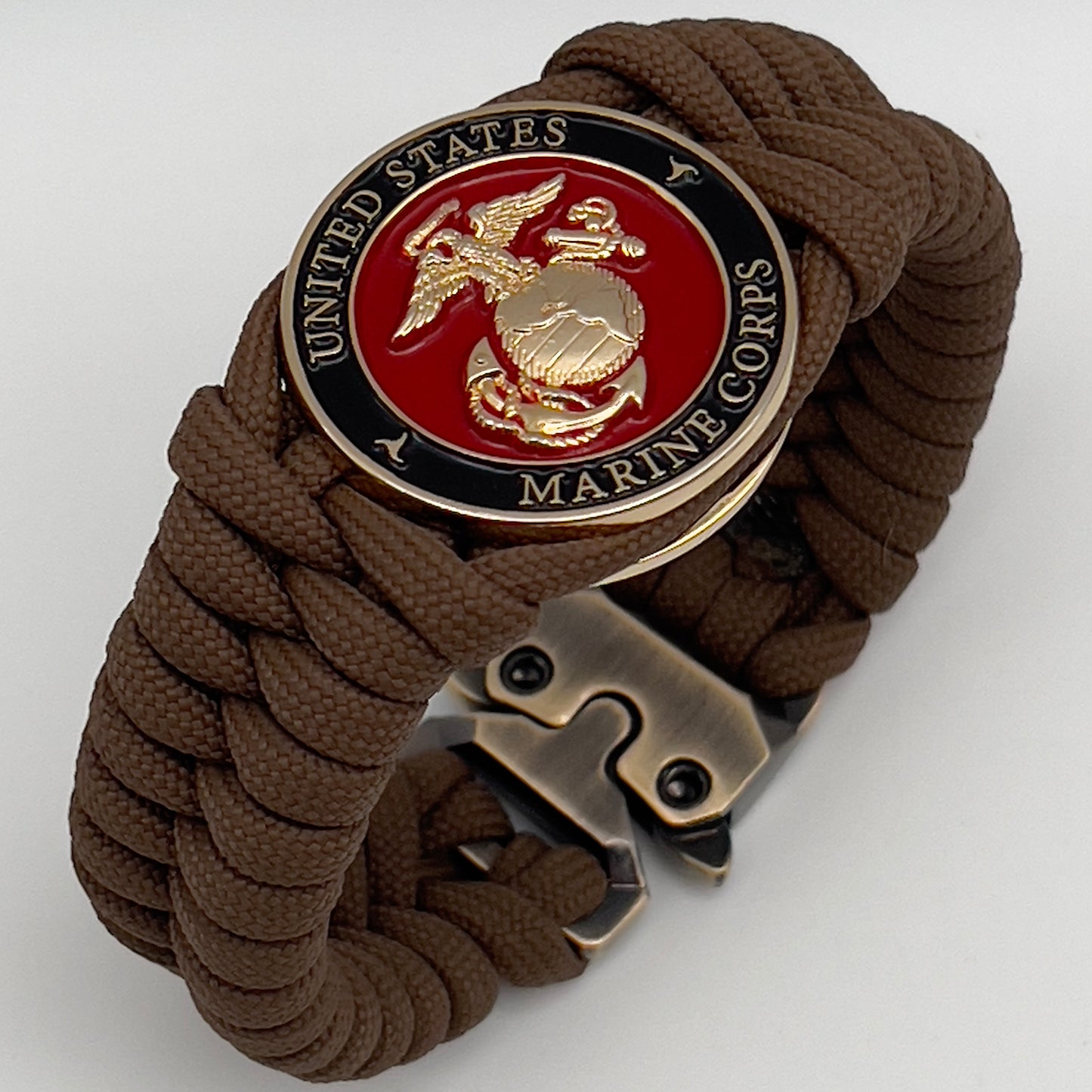 Thick, semi-rigid and comfortable braided United States Marine Corps bracelet featuring a 24K gold plated USMC Eagle Globe and Anchor medallion, a gold Cobra style tactical buckle and woven with Coyote Brown 550 paracord.