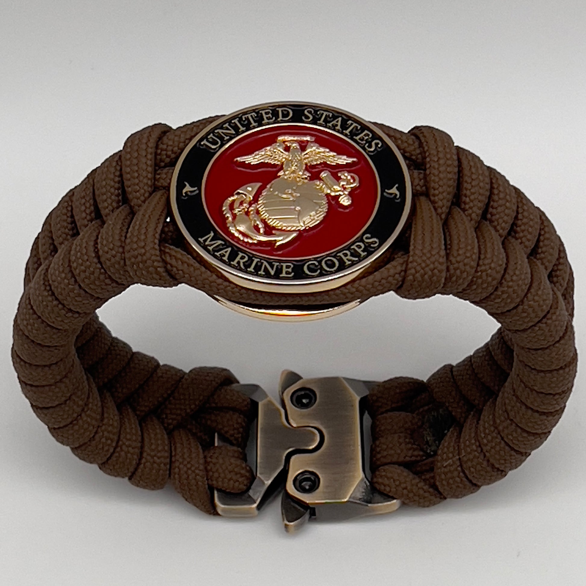 Thick, semi-rigid and comfortable braided United States Marine Corps bracelet featuring a 24K gold plated USMC Eagle Globe and Anchor medallion, a gold Cobra style tactical buckle and woven with Coyote Brown 550 paracord.