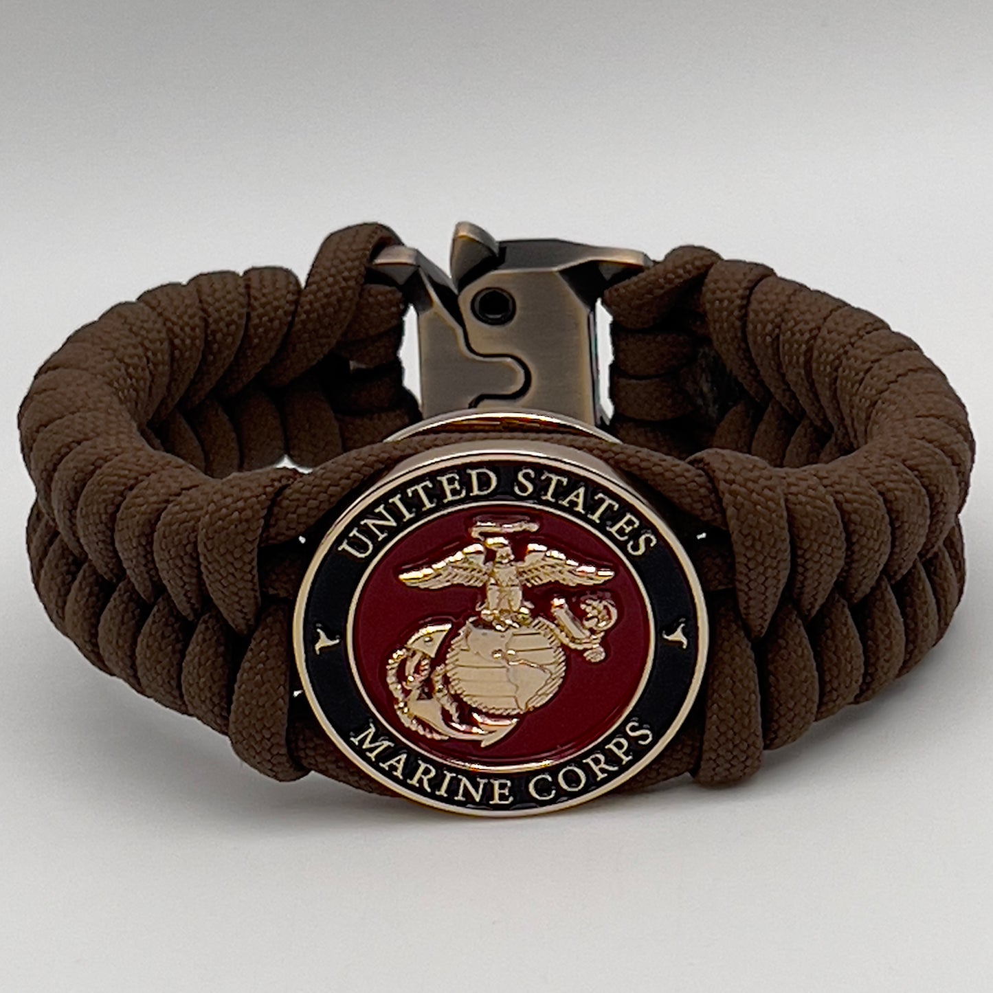 Thick, semi-rigid and comfortable braided United States Marine Corps bracelet featuring a 24K gold plated USMC Eagle Globe and Anchor medallion, a gold Cobra style tactical buckle and woven with Coyote Brown 550 paracord.