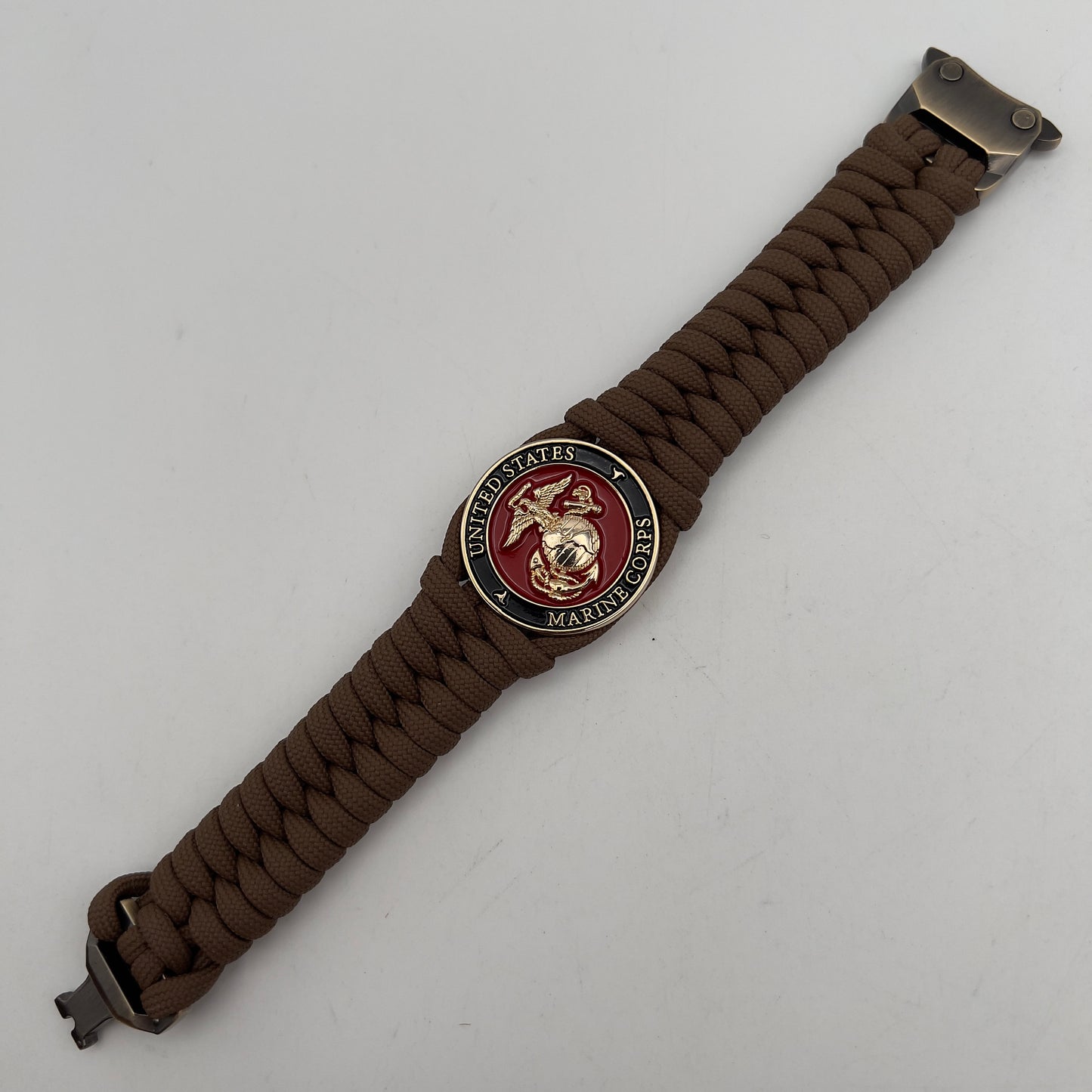 Thick, semi-rigid and comfortable braided United States Marine Corps bracelet featuring a 24K gold plated USMC Eagle Globe and Anchor medallion, a gold Cobra style tactical buckle and woven with Coyote Brown 550 paracord.
