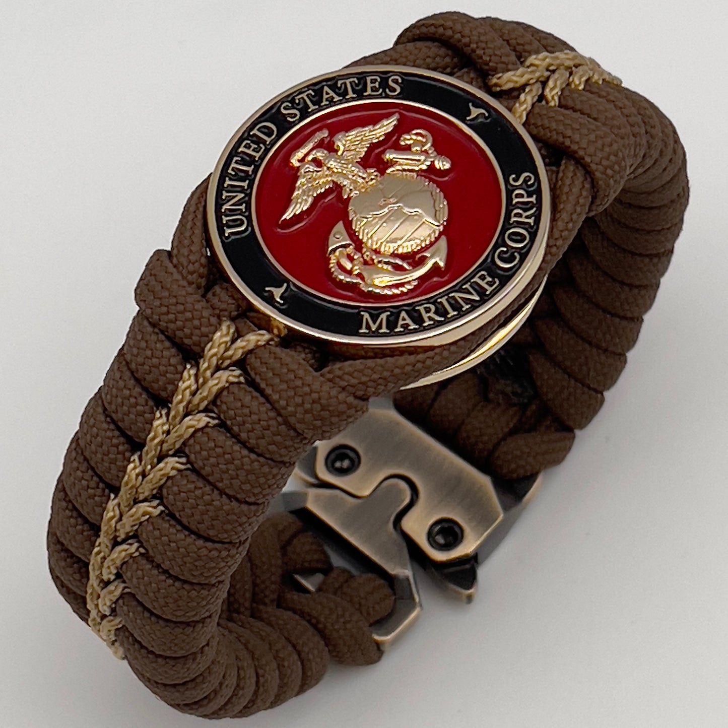 Thick, rigid and comfortable braided United States Marine Corps bracelet featuring a 24K gold plated USMC Eagle Globe and Anchor medallion, a gold Cobra style tactical buckle and woven with Coyote Brown 550 paracord and gold micro cord.