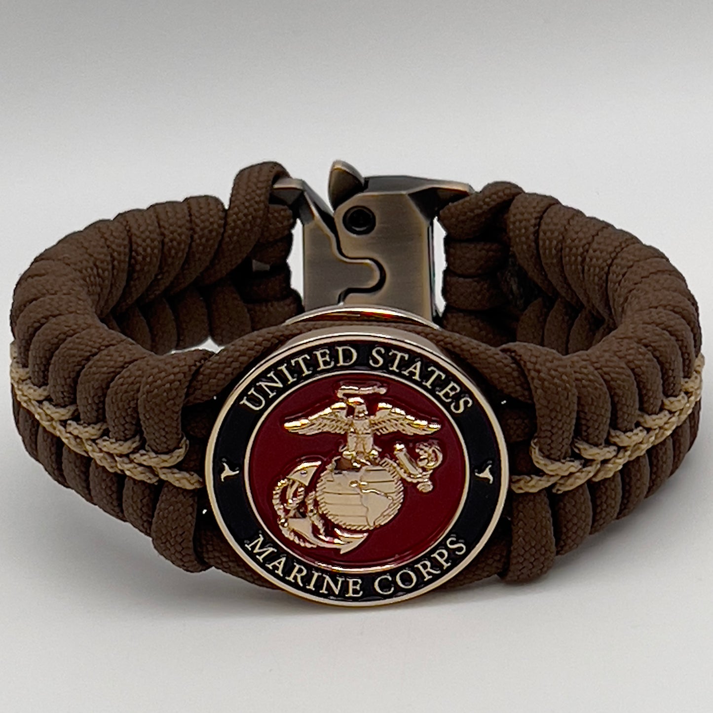 Thick, rigid and comfortable braided United States Marine Corps bracelet featuring a 24K gold plated USMC Eagle Globe and Anchor medallion, a gold Cobra style tactical buckle and woven with Coyote Brown 550 paracord and gold micro cord.
