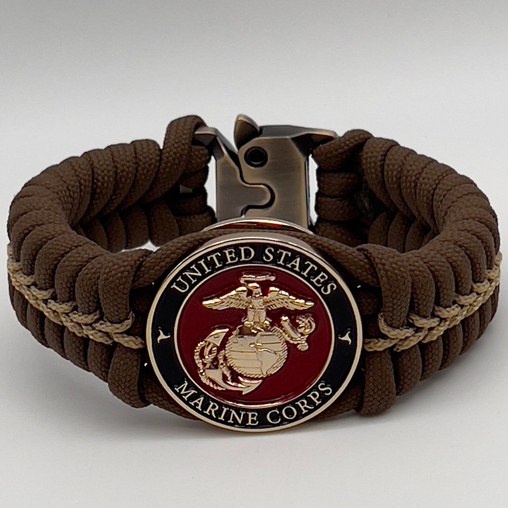 Thick, rigid and comfortable braided United States Marine Corps bracelet featuring a 24K gold plated USMC Eagle Globe and Anchor medallion, a gold Cobra style tactical buckle and woven with Coyote Brown 550 paracord and gold micro cord.