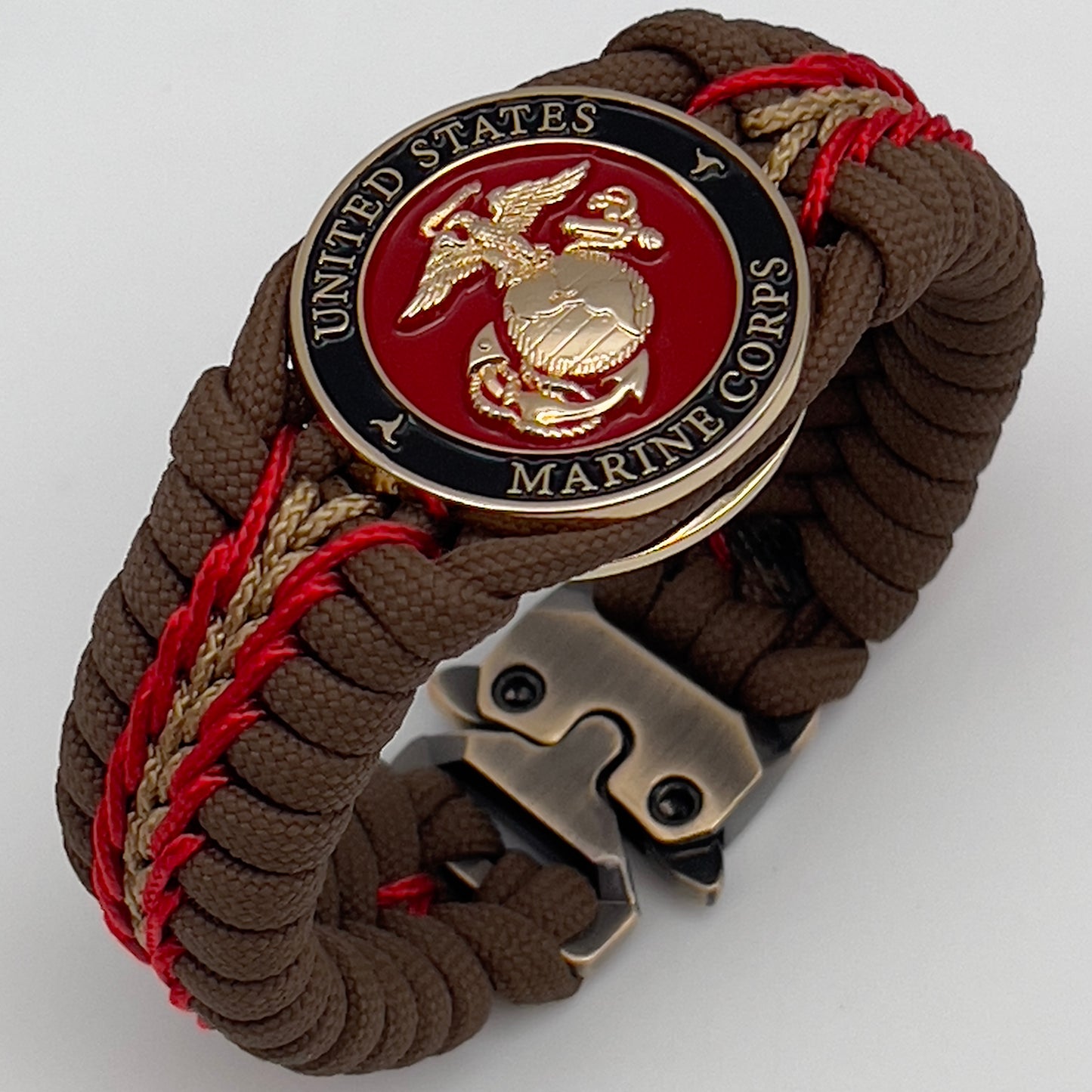 Thick, rigid and comfortable braided United States Marine Corps bracelet featuring a 24K gold plated USMC Eagle Globe and Anchor medallion, a gold Cobra style tactical buckle and woven with Coyote Brown 550 paracord and Imperial Red and gold micro cord.