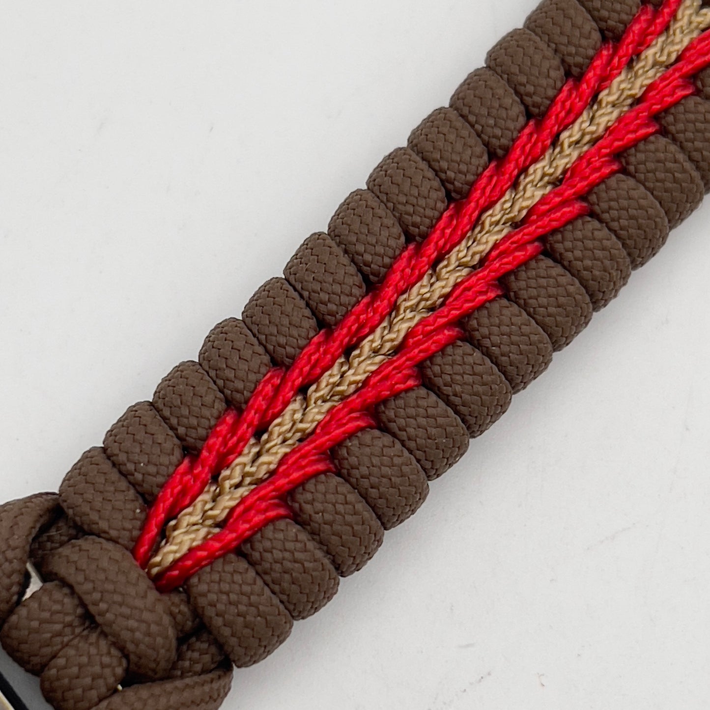 Thick, rigid and comfortable braided United States Marine Corps bracelet featuring a 24K gold plated USMC Eagle Globe and Anchor medallion, a gold Cobra style tactical buckle and woven with Coyote Brown 550 paracord and Imperial Red and gold micro cord.
