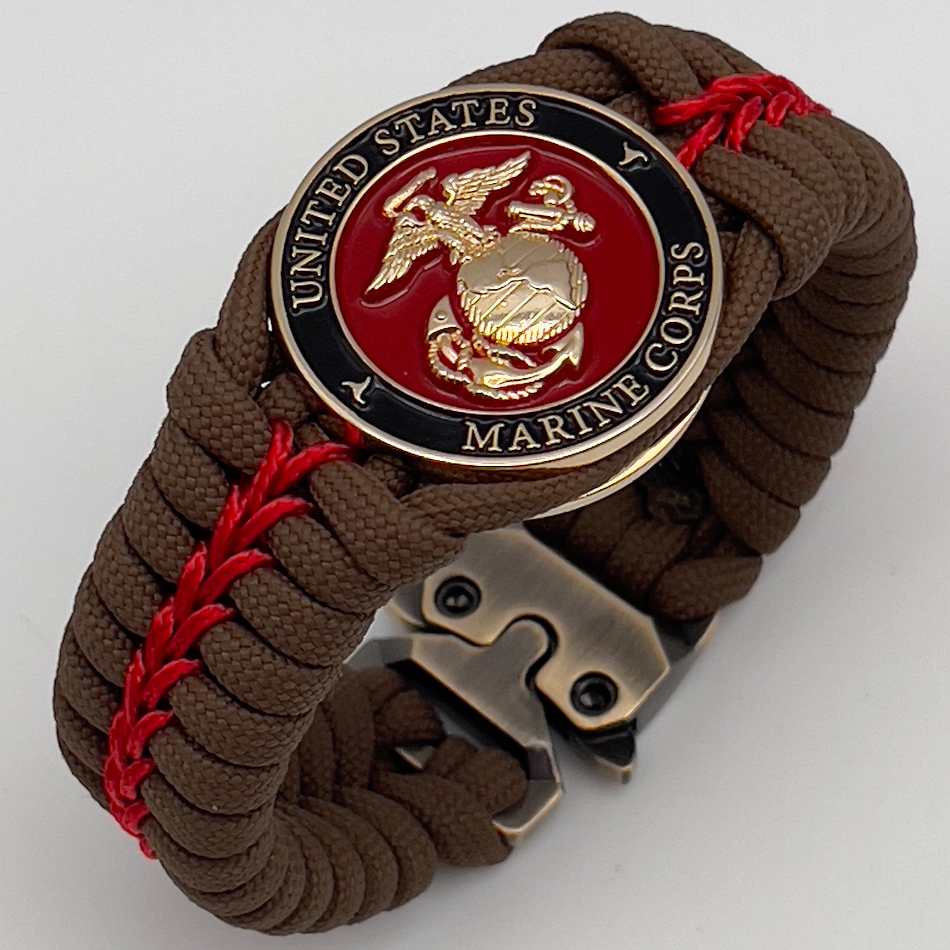 Thick, rigid and comfortable braided United States Marine Corps bracelet featuring a 24K gold plated USMC Eagle Globe and Anchor medallion, a gold Cobra style tactical buckle and woven with Coyote Brown 550 paracord and Imperial Red micro cord.