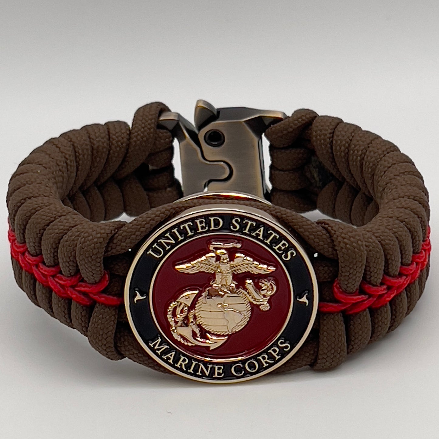 Thick, rigid and comfortable braided United States Marine Corps bracelet featuring a 24K gold plated USMC Eagle Globe and Anchor medallion, a gold Cobra style tactical buckle and woven with Coyote Brown 550 paracord and Imperial Red micro cord.
