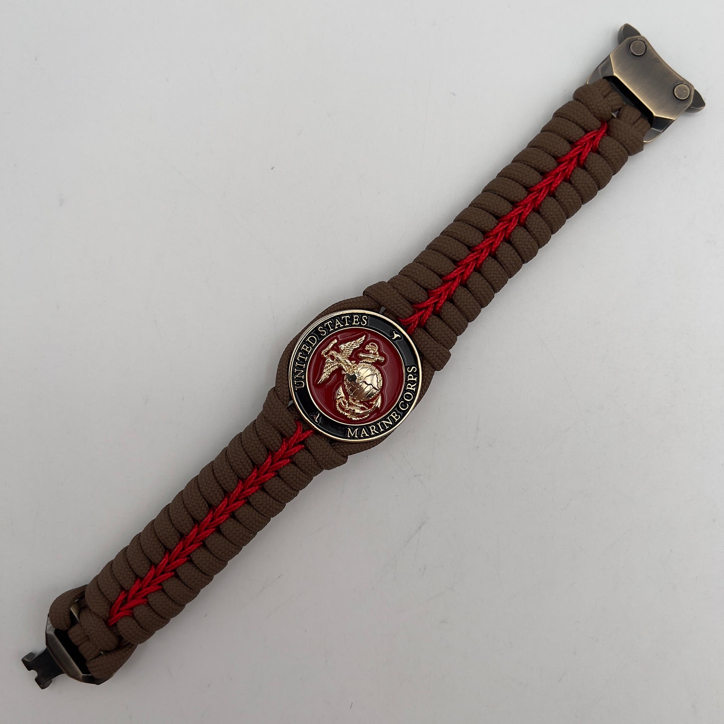 Thick, rigid and comfortable braided United States Marine Corps bracelet featuring a 24K gold plated USMC Eagle Globe and Anchor medallion, a gold Cobra style tactical buckle and woven with Coyote Brown 550 paracord and Imperial Red micro cord.