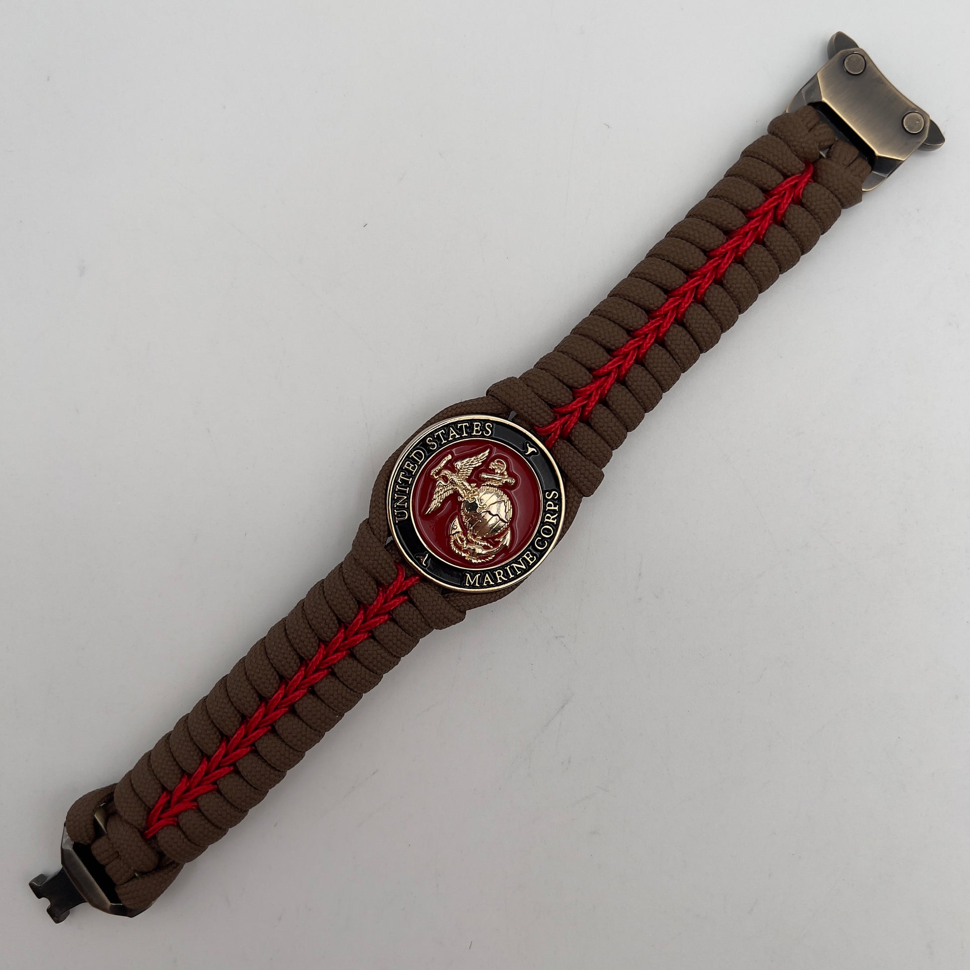 Thick, rigid and comfortable braided United States Marine Corps bracelet featuring a 24K gold plated USMC Eagle Globe and Anchor medallion, a gold Cobra style tactical buckle and woven with Coyote Brown 550 paracord and Imperial Red micro cord.