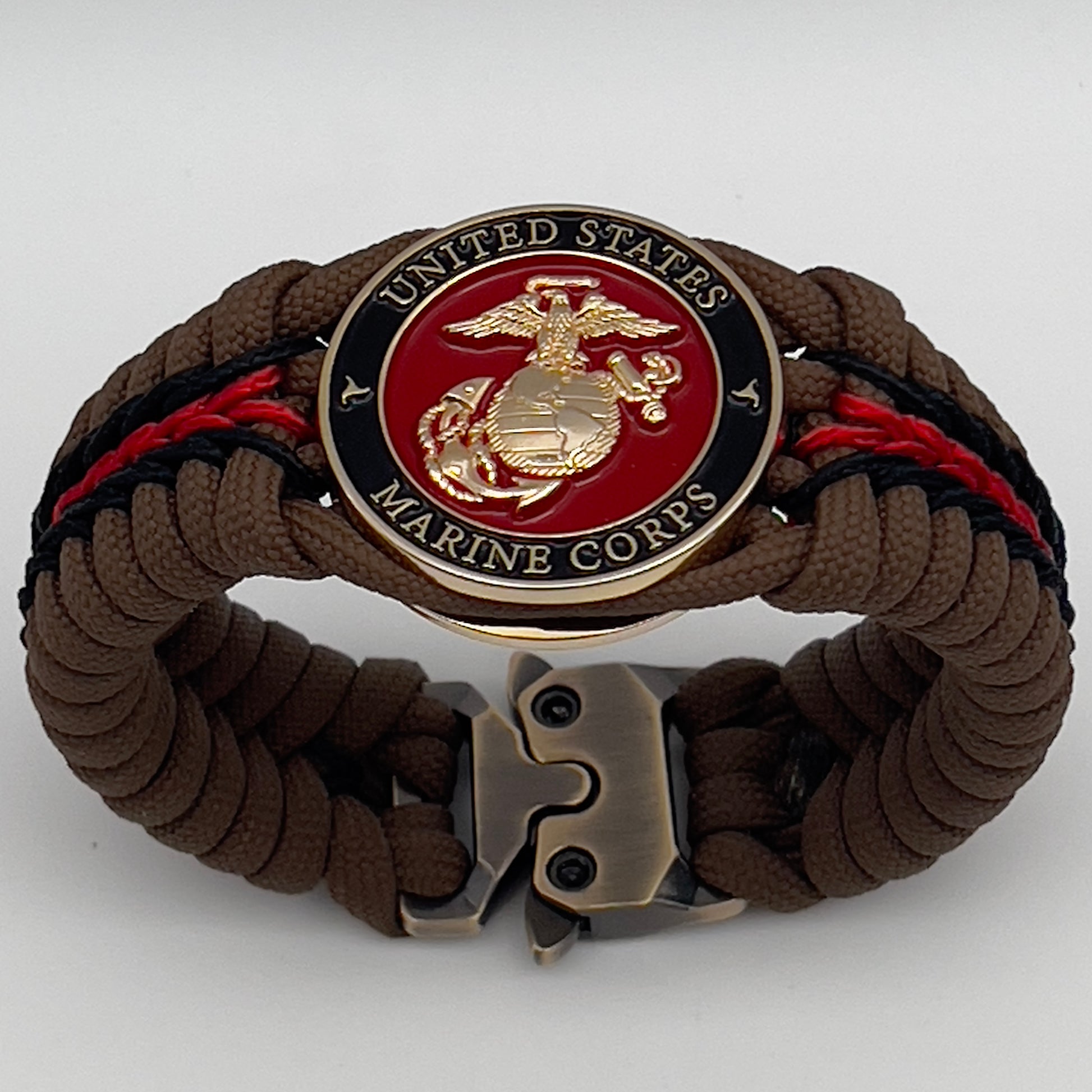 Thick, rigid and comfortable braided United States Marine Corps bracelet featuring a 24K gold plated USMC Eagle Globe and Anchor medallion, a gold Cobra style tactical buckle and woven with Coyote Brown 550 paracord and Imperial Red and black micro cord.