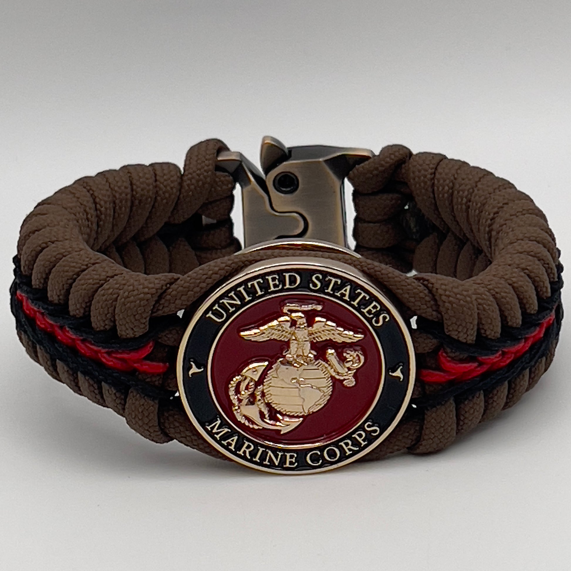 Thick, rigid and comfortable braided United States Marine Corps bracelet featuring a 24K gold plated USMC Eagle Globe and Anchor medallion, a gold Cobra style tactical buckle and woven with Coyote Brown 550 paracord and Imperial Red and black micro cord.