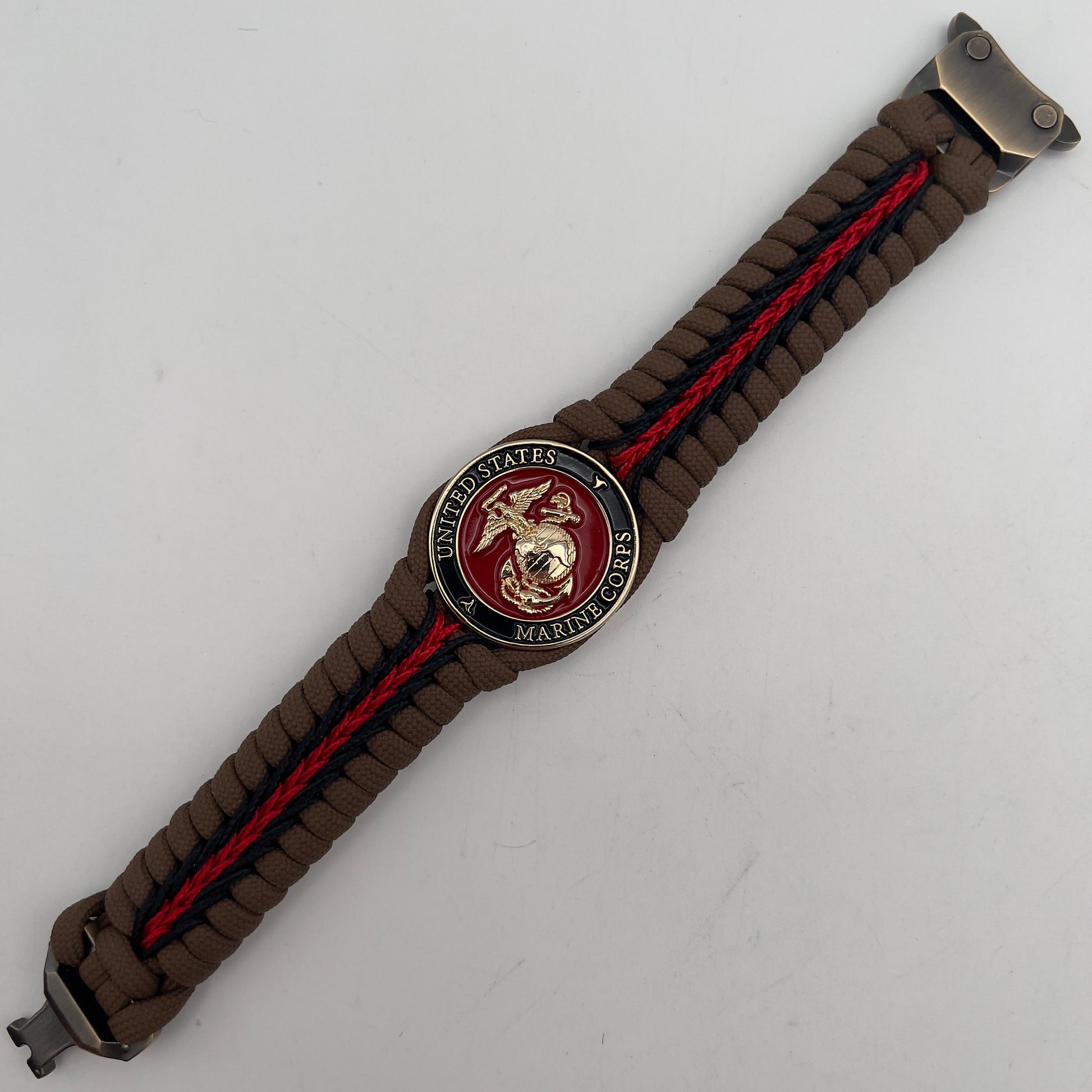 Thick, rigid and comfortable braided United States Marine Corps bracelet featuring a 24K gold plated USMC Eagle Globe and Anchor medallion, a gold Cobra style tactical buckle and woven with Coyote Brown 550 paracord and Imperial Red and black micro cord.