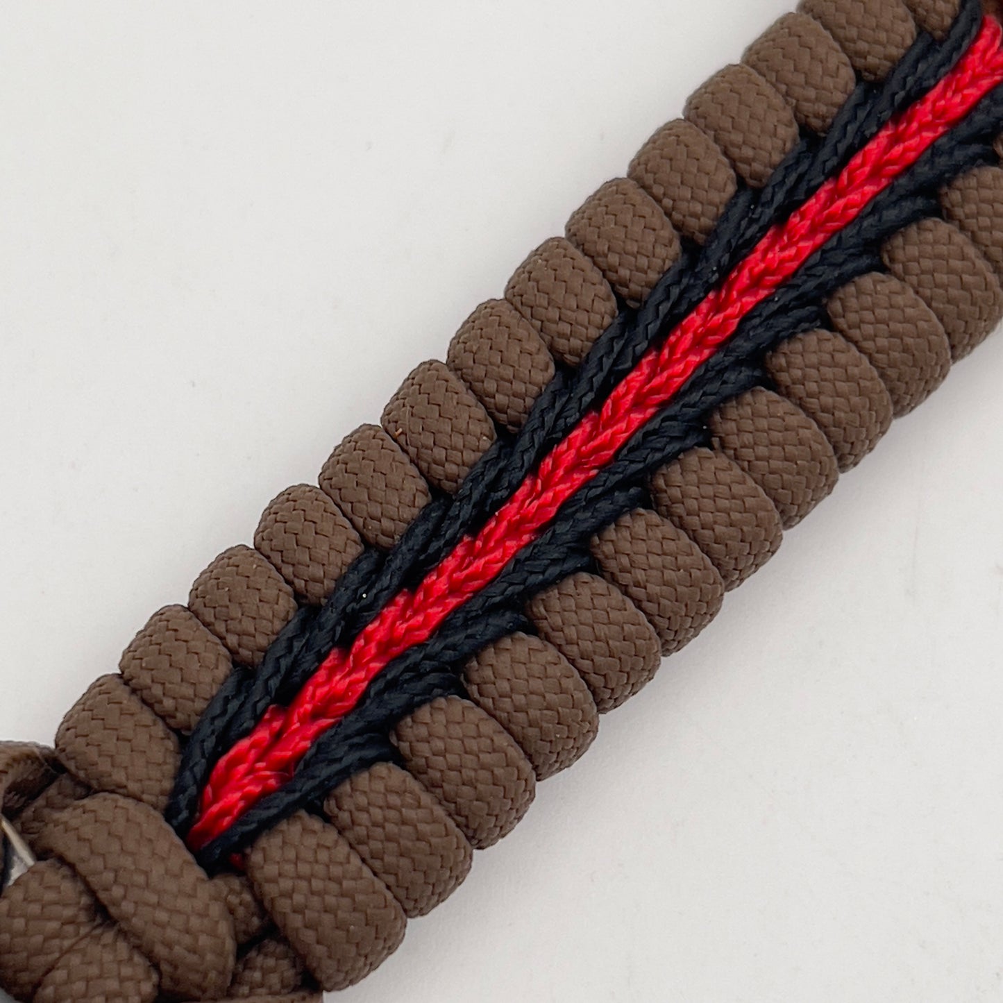 Thick, rigid and comfortable braided United States Marine Corps bracelet featuring a 24K gold plated USMC Eagle Globe and Anchor medallion, a gold Cobra style tactical buckle and woven with Coyote Brown 550 paracord and Imperial Red and black micro cord.
