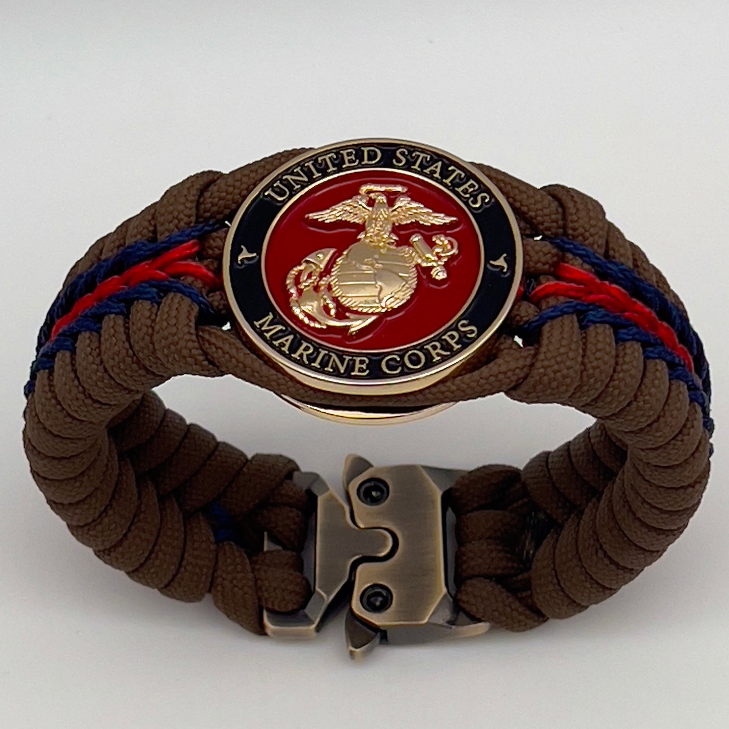 Thick, rigid and comfortable braided United States Marine Corps bracelet featuring a 24K gold plated USMC Eagle Globe and Anchor medallion, a gold Cobra style tactical buckle and woven with Coyote Brown 550 paracord and Imperial Red and Navy Blue micro cord.