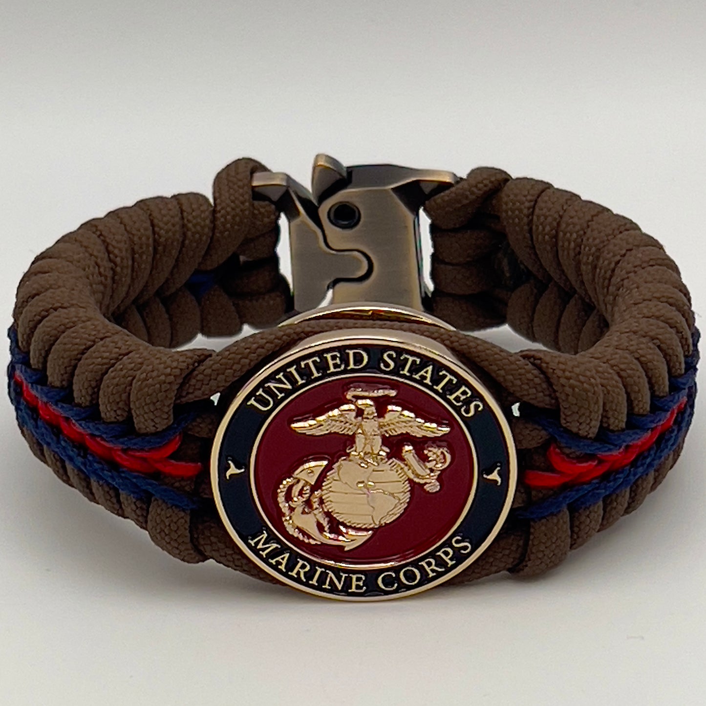 Thick, rigid and comfortable braided United States Marine Corps bracelet featuring a 24K gold plated USMC Eagle Globe and Anchor medallion, a gold Cobra style tactical buckle and woven with Coyote Brown 550 paracord and Imperial Red and Navy Blue micro cord.