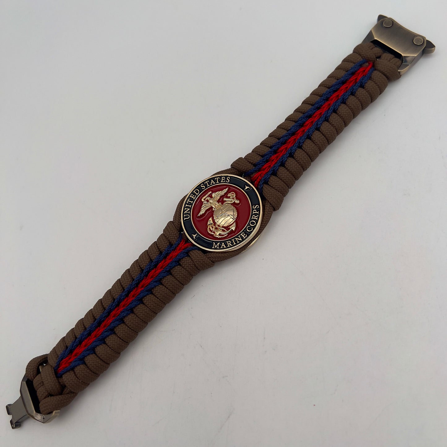 Thick, rigid and comfortable braided United States Marine Corps bracelet featuring a 24K gold plated USMC Eagle Globe and Anchor medallion, a gold Cobra style tactical buckle and woven with Coyote Brown 550 paracord and Imperial Red and Navy Blue micro cord.