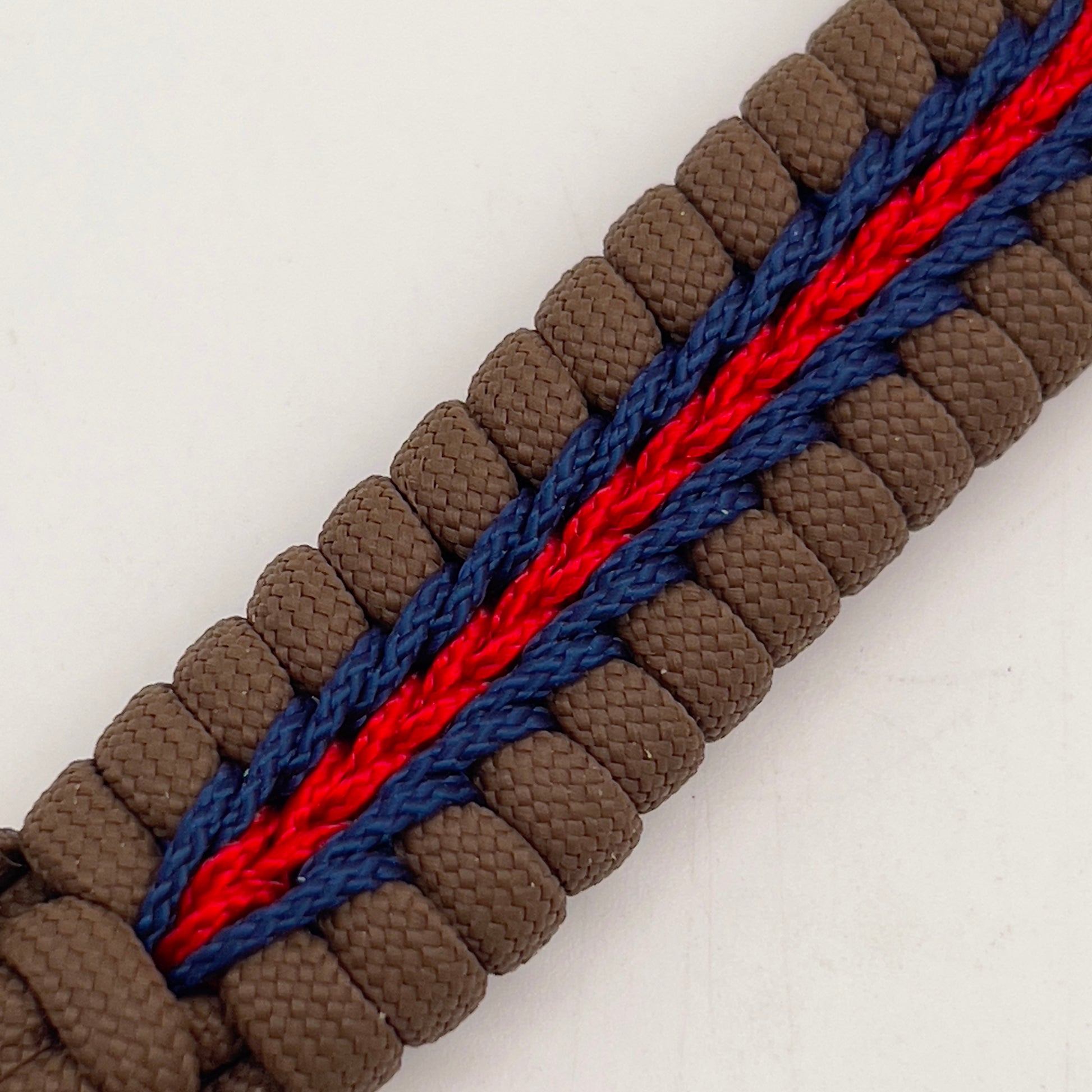 Thick, rigid and comfortable braided United States Marine Corps bracelet featuring a 24K gold plated USMC Eagle Globe and Anchor medallion, a gold Cobra style tactical buckle and woven with Coyote Brown 550 paracord and Imperial Red and Navy Blue micro cord.