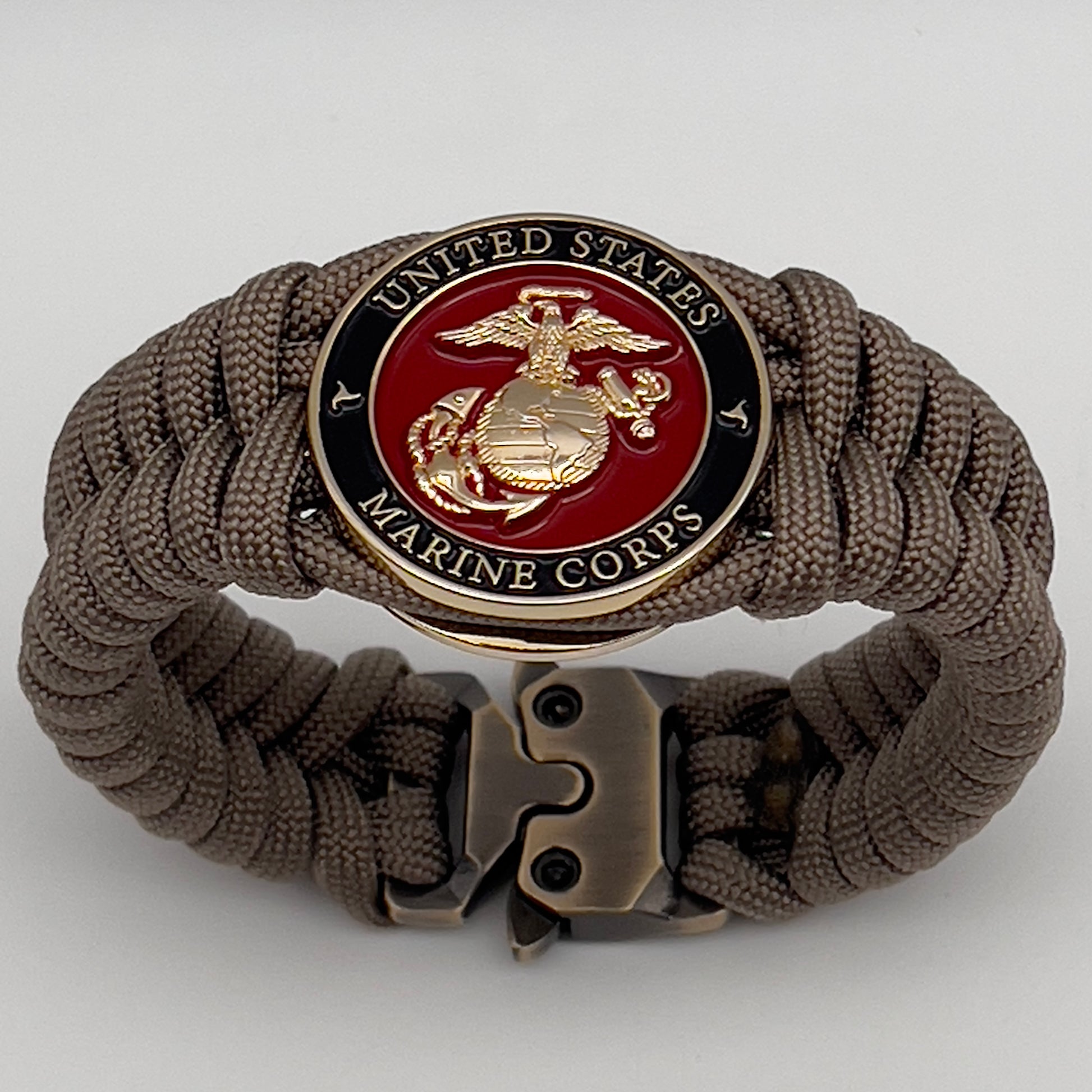 Thick, semi-rigid and comfortable braided United States Marine Corps bracelet featuring a 24K gold plated USMC Eagle Globe and Anchor medallion, a gold Cobra style tactical buckle and woven with tan 550 paracord.