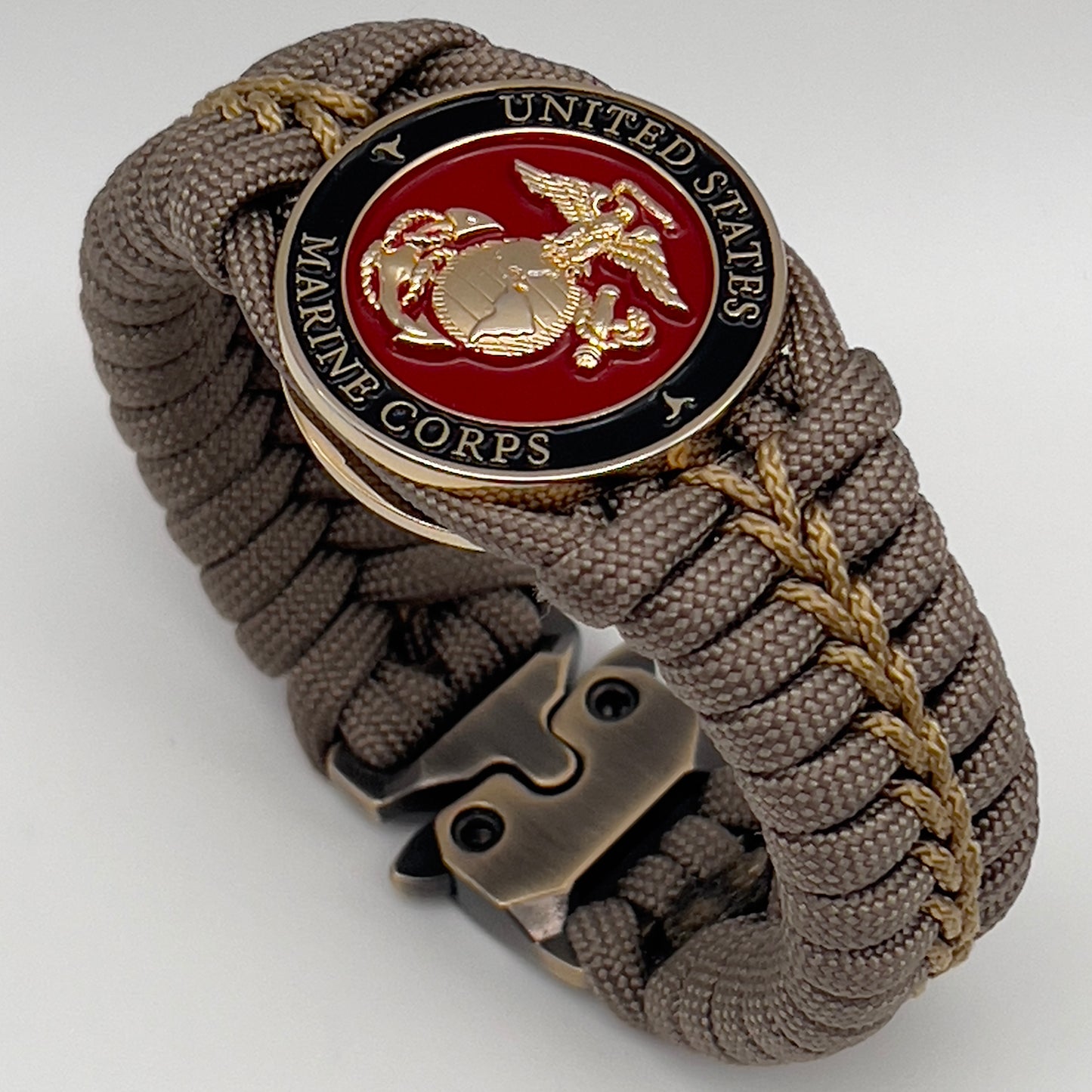 Thick, semi-rigid and comfortable braided United States Marine Corps bracelet featuring a 24K gold plated USMC Eagle Globe and Anchor medallion, a gold Cobra style tactical buckle and woven with tan 550 paracord and gold micro cord.