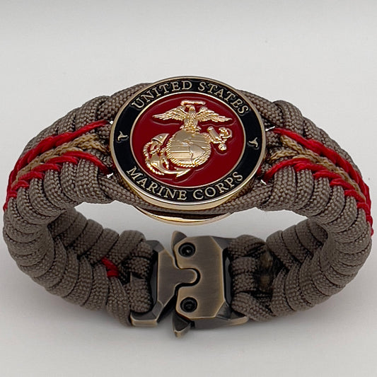 Thick, rigid and comfortable braided United States Marine Corps bracelet featuring a 24K gold plated USMC Eagle Globe and Anchor medallion, a gold Cobra style tactical buckle and woven with tan 550 paracord and Imperial Red and gold micro cord.