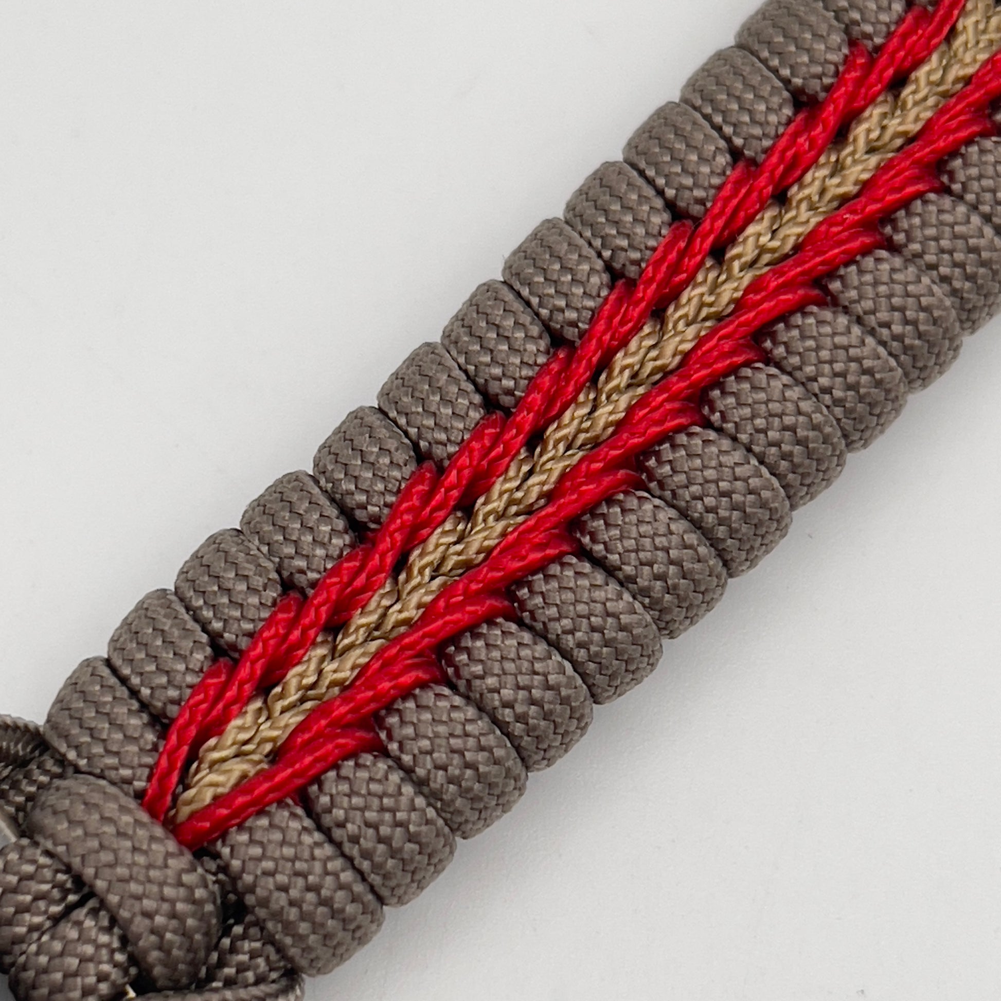 Thick, rigid and comfortable braided United States Marine Corps bracelet featuring a 24K gold plated USMC Eagle Globe and Anchor medallion, a gold Cobra style tactical buckle and woven with tan 550 paracord and Imperial Red and gold micro cord.
