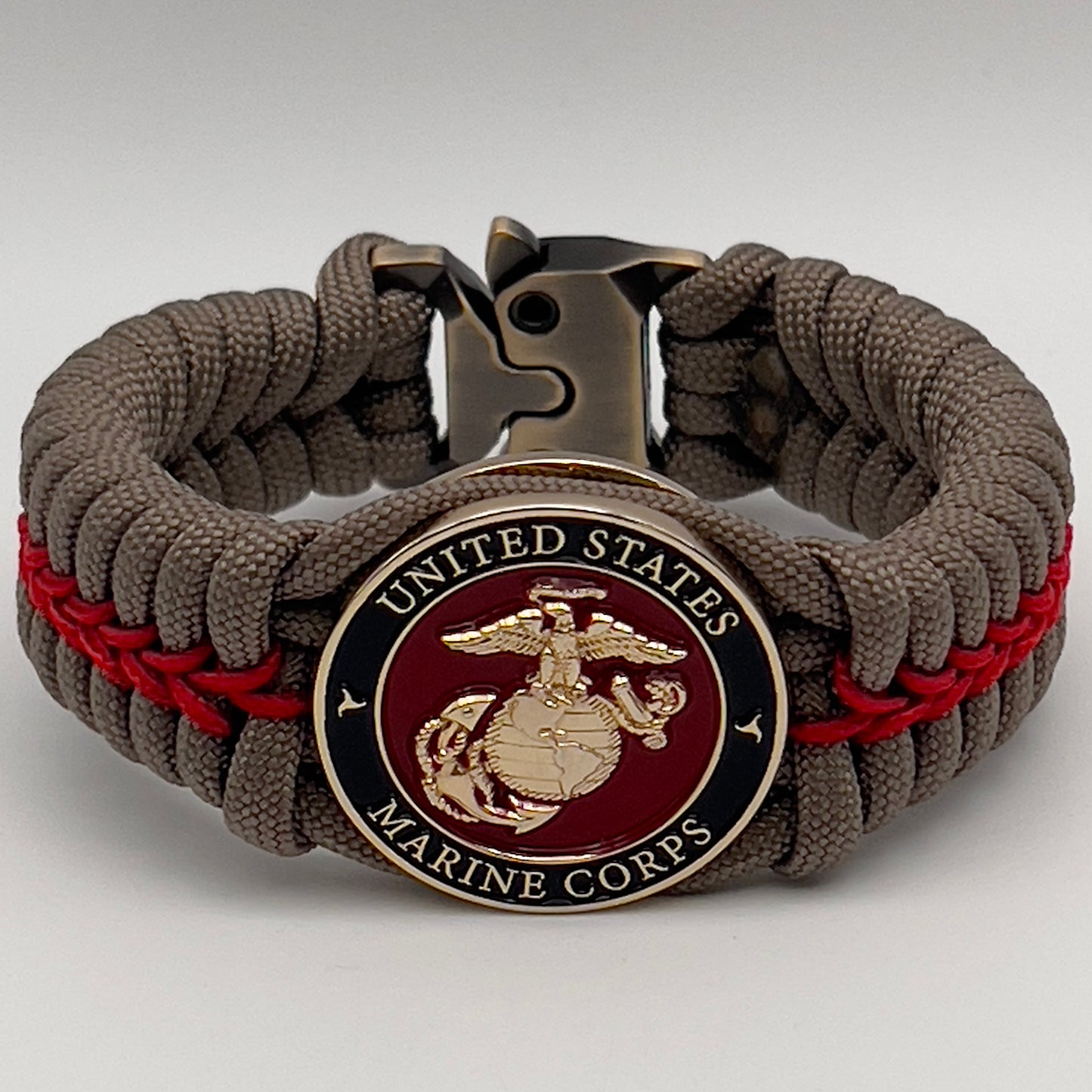 Thick, rigid and comfortable braided United States Marine Corps bracelet featuring a 24K gold plated USMC Eagle Globe and Anchor medallion, a gold Cobra style tactical buckle and woven with tan 550 paracord and Imperial Red micro cord.