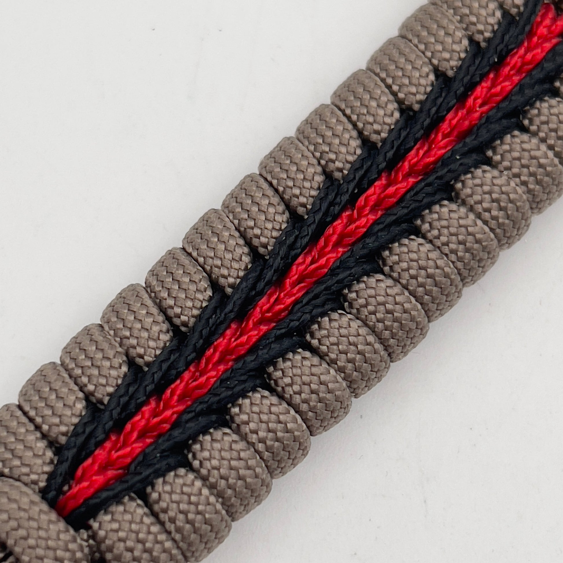 Thick, rigid and comfortable braided United States Marine Corps bracelet featuring a 24K gold plated USMC Eagle Globe and Anchor medallion, a gold Cobra style tactical buckle and woven with tan 550 paracord and Imperial Red and black micro cord.