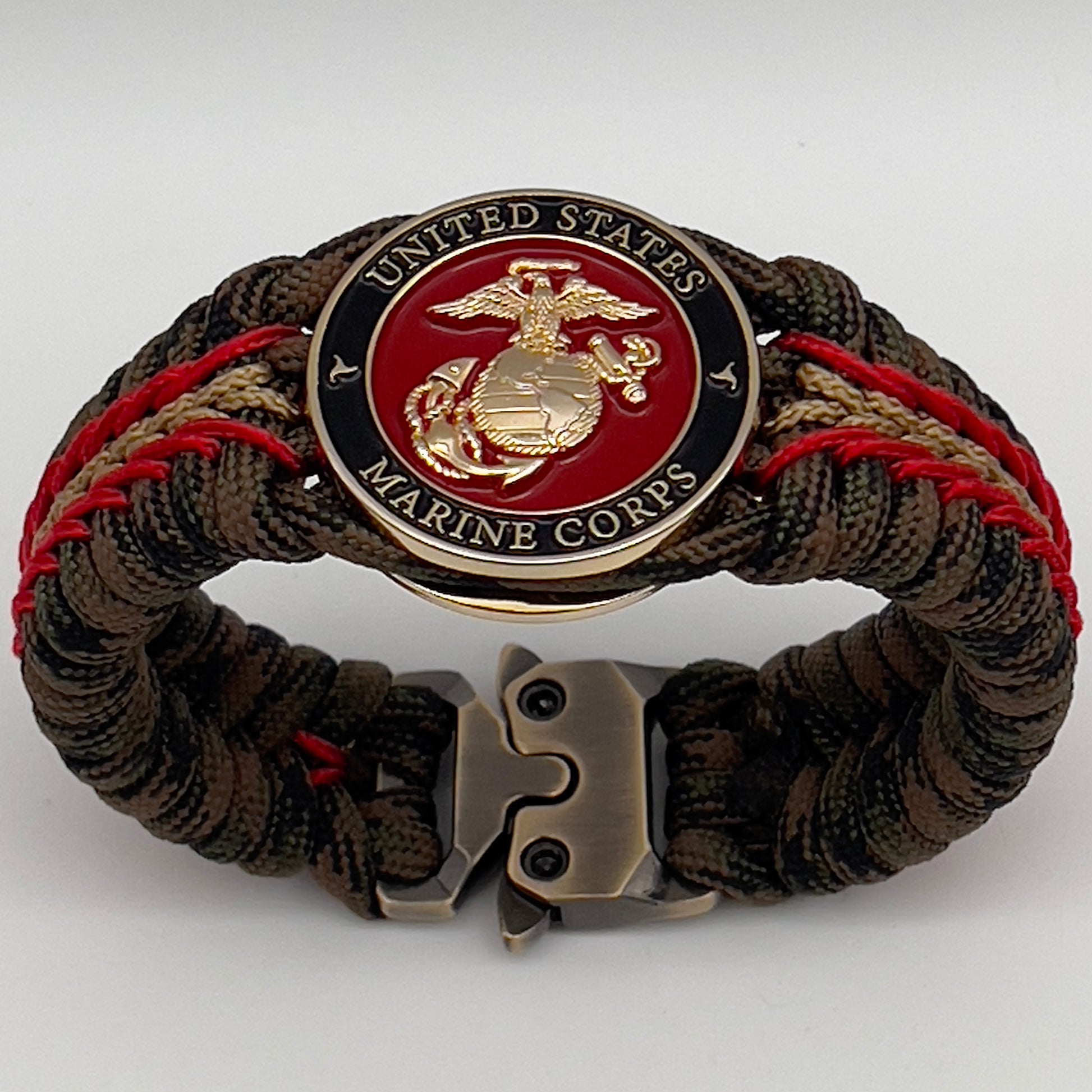 Thick, rigid and comfortable braided United States Marine Corps bracelet featuring a 24K gold plated USMC Eagle Globe and Anchor medallion, a gold Cobra style tactical buckle and woven with Woodland camo 550 paracord and Imperial Red and Gold micro cord.