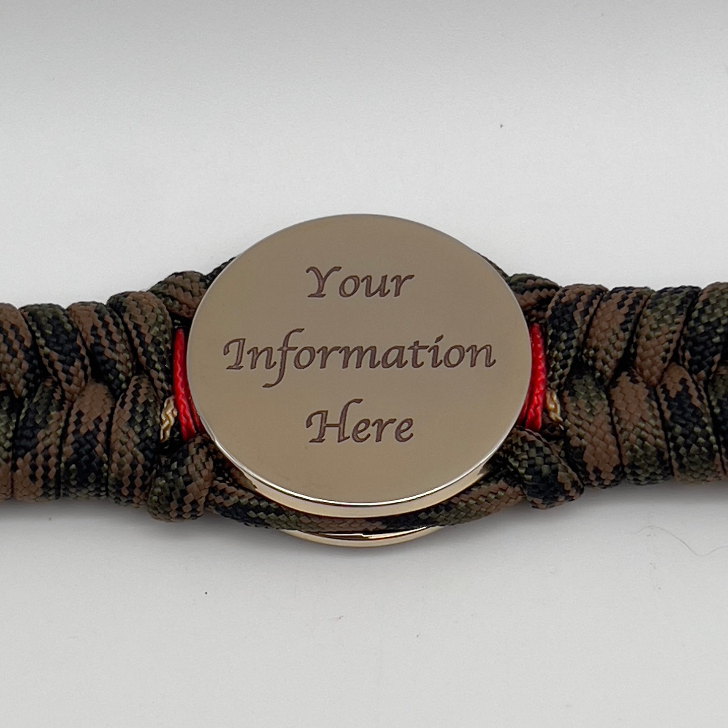 Thick, rigid and comfortable braided United States Marine Corps bracelet featuring a 24K gold plated USMC Eagle Globe and Anchor medallion, a gold Cobra style tactical buckle and woven with Woodland camo 550 paracord and Imperial Red and Gold micro cord.