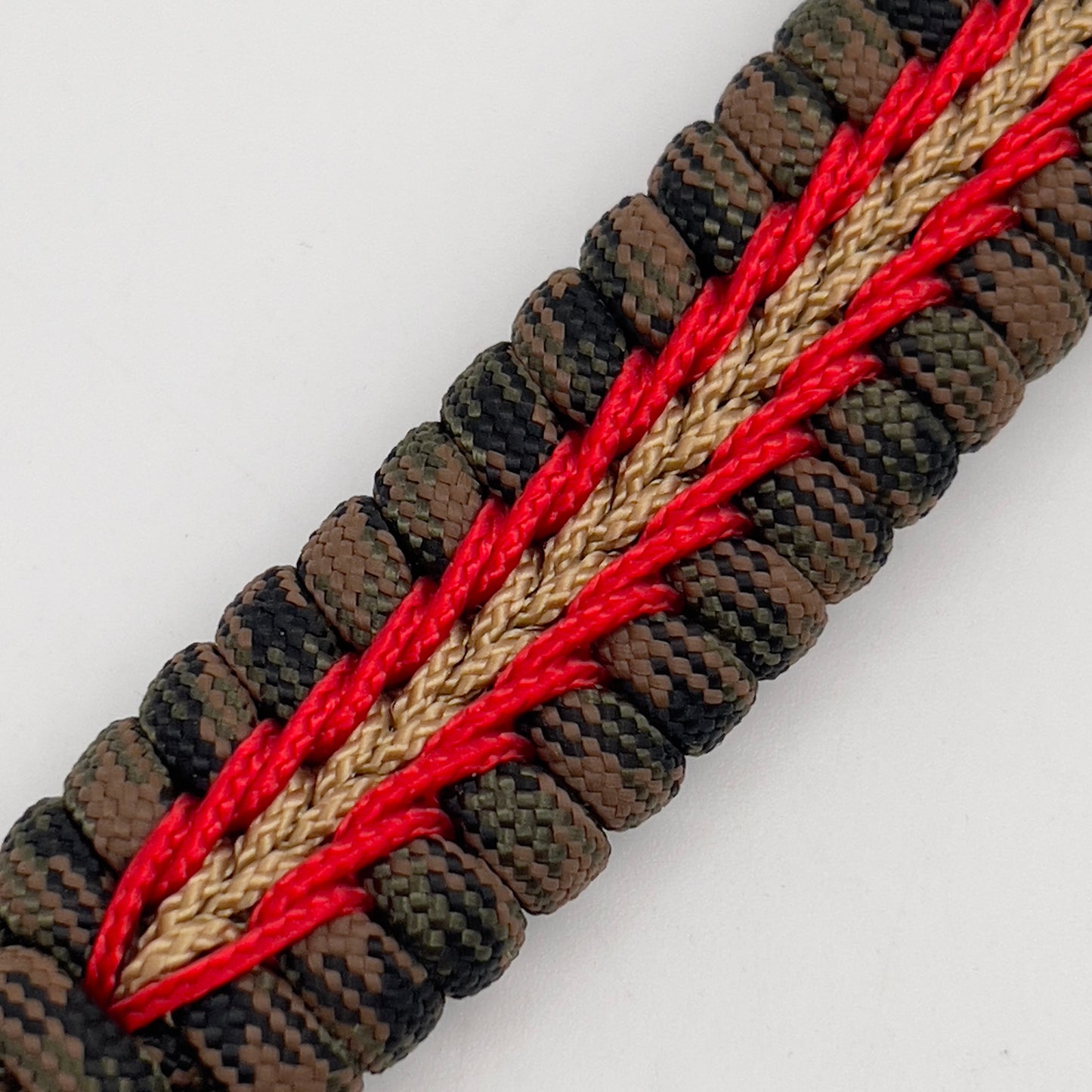 Thick, rigid and comfortable braided United States Marine Corps bracelet featuring a 24K gold plated USMC Eagle Globe and Anchor medallion, a gold Cobra style tactical buckle and woven with Woodland camo 550 paracord and Imperial Red and Gold micro cord.
