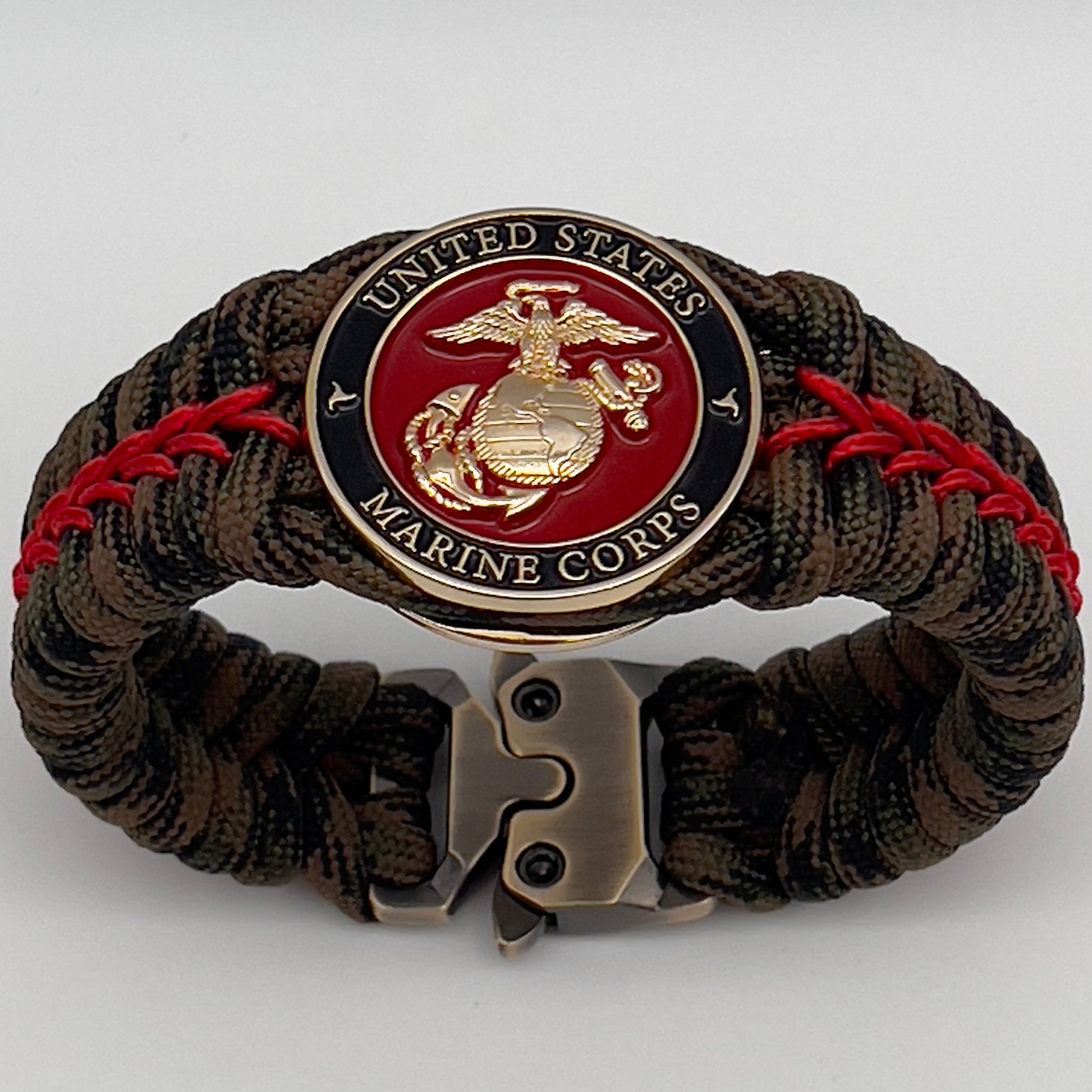 Thick, rigid and comfortable braided United States Marine Corps bracelet featuring a 24K gold plated USMC Eagle Globe and Anchor medallion, a gold Cobra style tactical buckle and woven with Woodland Camo 550 paracord and Imperial Red micro cord.