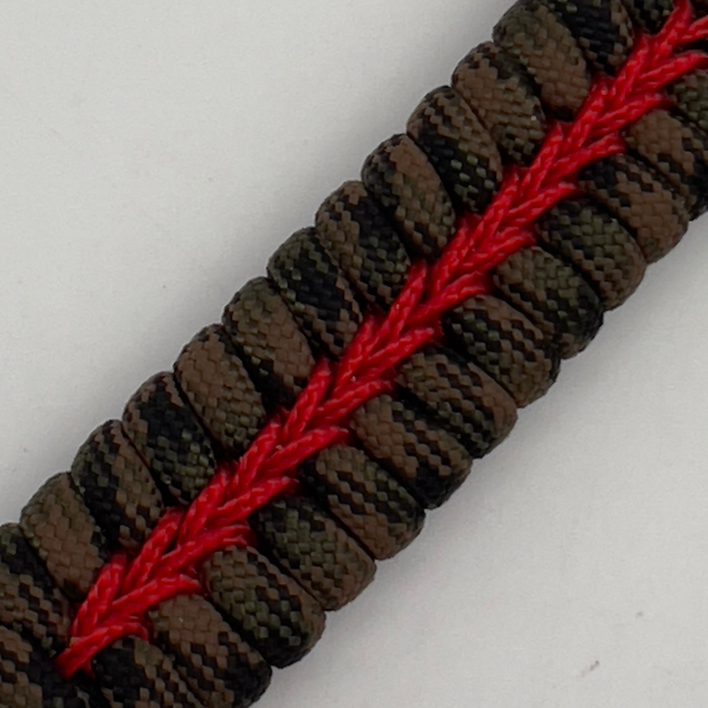 Thick, rigid and comfortable braided United States Marine Corps bracelet featuring a 24K gold plated USMC Eagle Globe and Anchor medallion, a gold Cobra style tactical buckle and woven with Woodland Camo 550 paracord and Imperial Red micro cord.