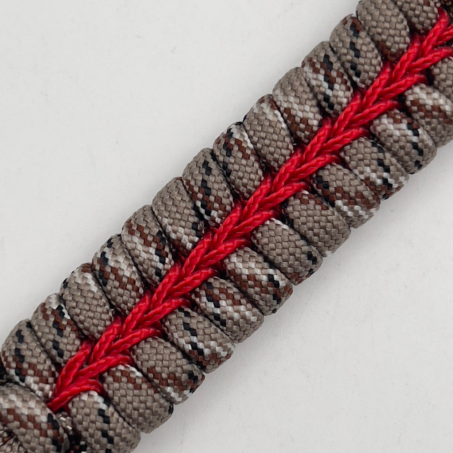 Thick, rigid and comfortable braided United States Marine Corps bracelet featuring a 24K gold plated USMC Eagle Globe and Anchor medallion, a gold Cobra style tactical buckle and woven with Desert Camo 550 paracord and Imperial Red micro cord.