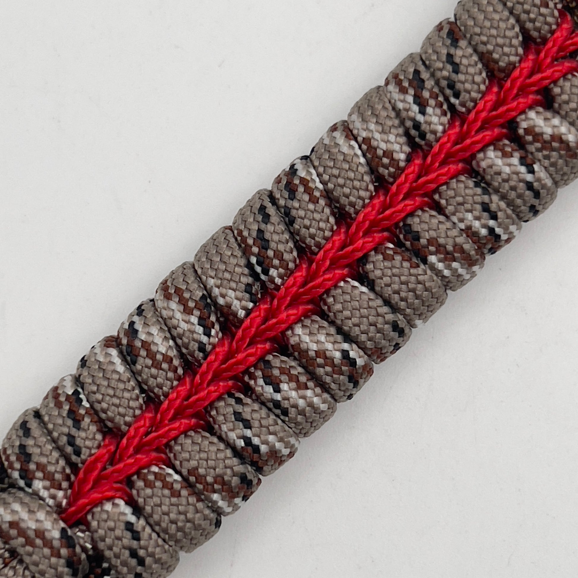 Thick, rigid and comfortable braided United States Marine Corps bracelet featuring a 24K gold plated USMC Eagle Globe and Anchor medallion, a gold Cobra style tactical buckle and woven with Desert Camo 550 paracord and Imperial Red micro cord.