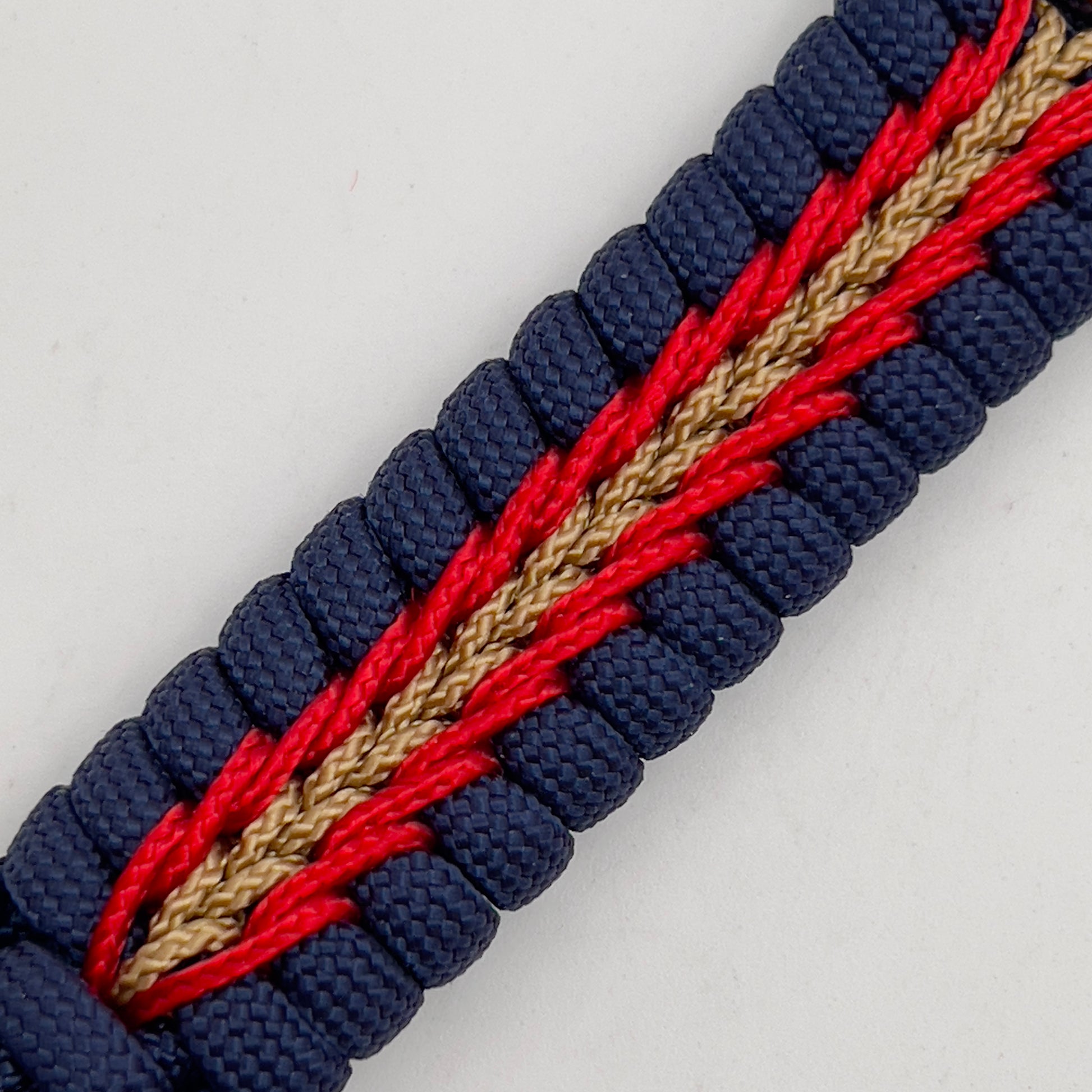 Thick, rigid and comfortable braided United States Marine Corps bracelet featuring a 24K gold plated USMC Eagle Globe and Anchor medallion, a gold Cobra style tactical buckle and woven with Navy Blue 550 paracord and Imperial Red and Gold micro cord.