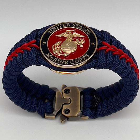 Thick, rigid and comfortable braided United States Marine Corps bracelet featuring a 24K gold plated USMC Eagle Globe and Anchor medallion, a gold Cobra style tactical buckle and woven withNavy Blue 550 paracord and Imperial Red micro cord.