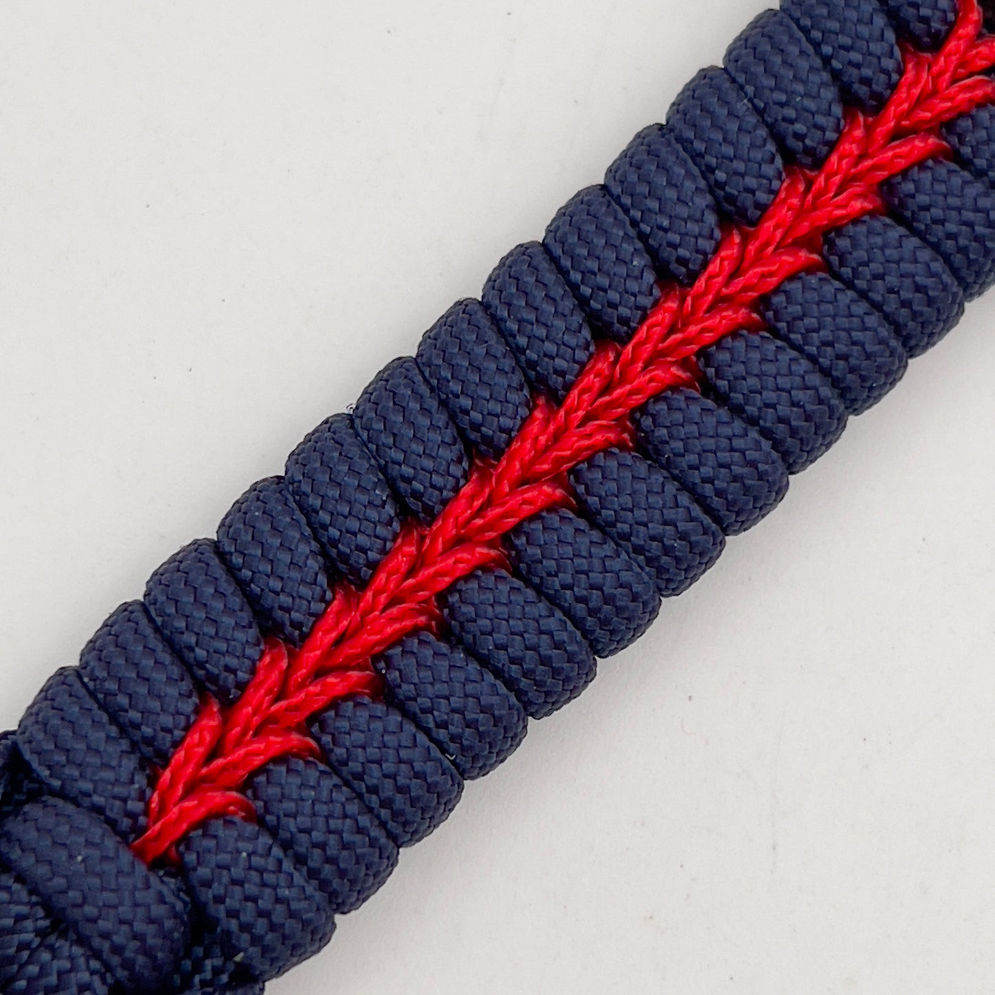 Thick, rigid and comfortable braided United States Marine Corps bracelet featuring a 24K gold plated USMC Eagle Globe and Anchor medallion, a gold Cobra style tactical buckle and woven withNavy Blue 550 paracord and Imperial Red micro cord.