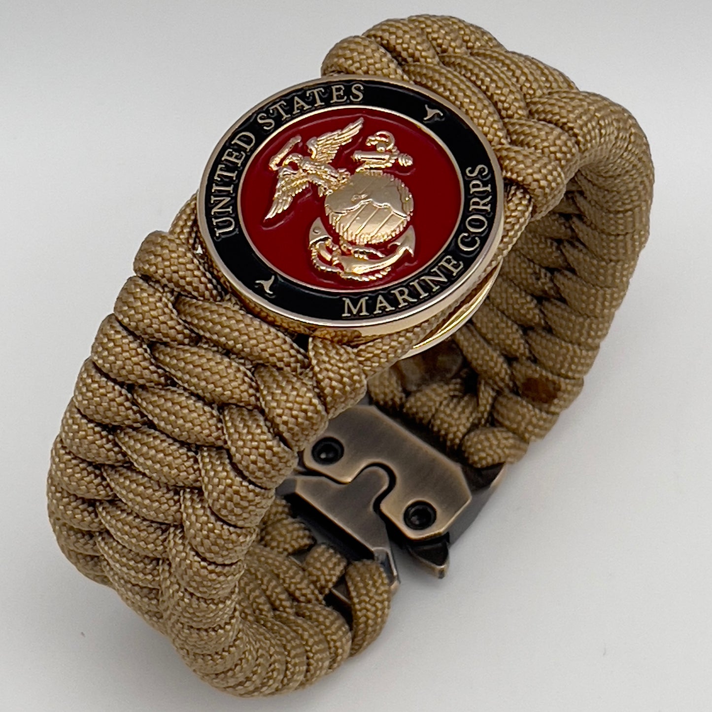 Thick, wide, rigid and comfortable braided United States Marine Corps bracelet featuring a 24K gold plated USMC Eagle Globe and Anchor medallion, a gold Cobra style tactical buckle and woven with gold 550 paracord.