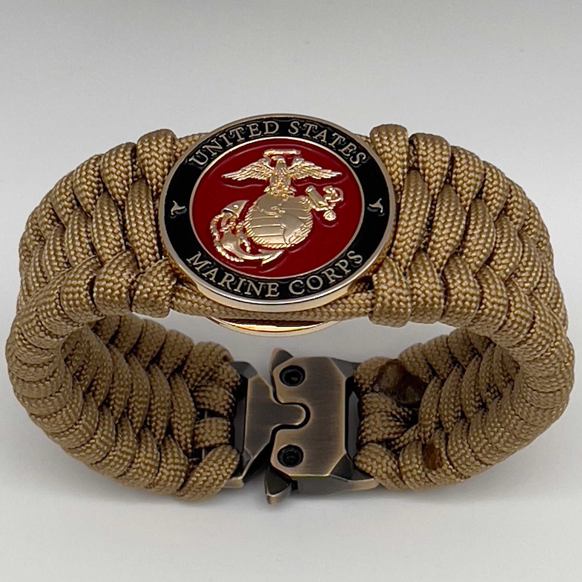 Thick, wide, rigid and comfortable braided United States Marine Corps bracelet featuring a 24K gold plated USMC Eagle Globe and Anchor medallion, a gold Cobra style tactical buckle and woven with gold 550 paracord.