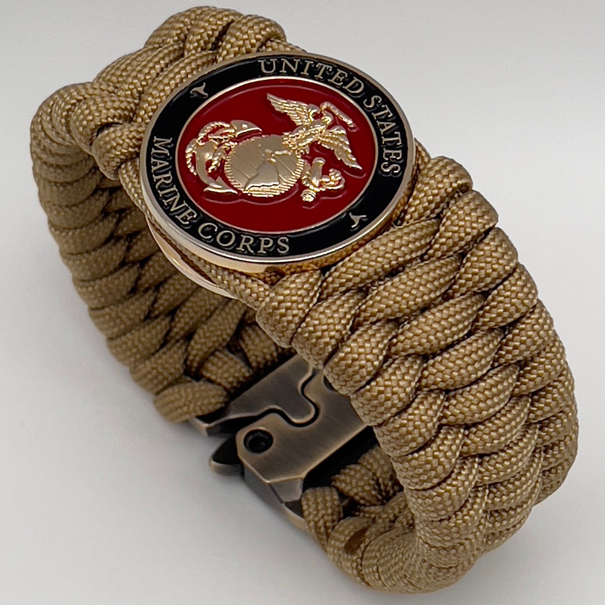 Thick, wide, rigid and comfortable braided United States Marine Corps bracelet featuring a 24K gold plated USMC Eagle Globe and Anchor medallion, a gold Cobra style tactical buckle and woven with gold 550 paracord.