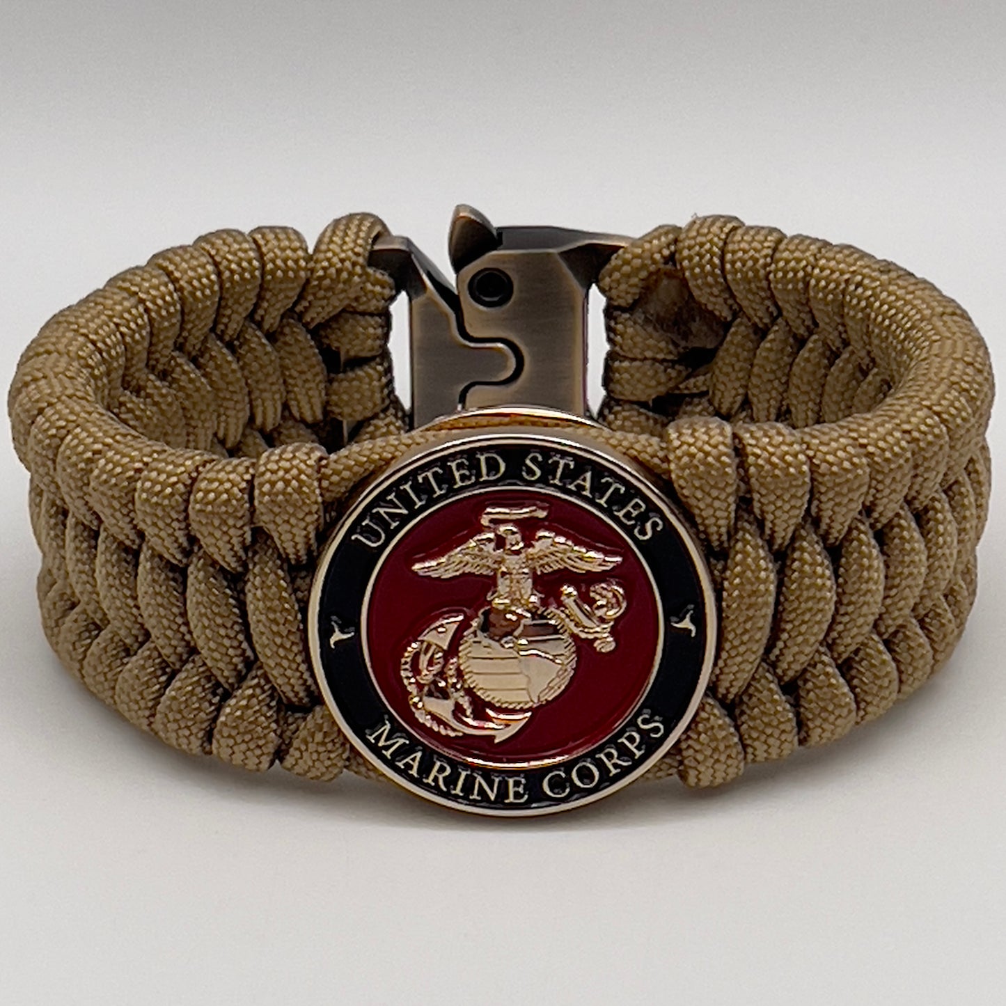 Thick, wide, rigid and comfortable braided United States Marine Corps bracelet featuring a 24K gold plated USMC Eagle Globe and Anchor medallion, a gold Cobra style tactical buckle and woven with gold 550 paracord.
