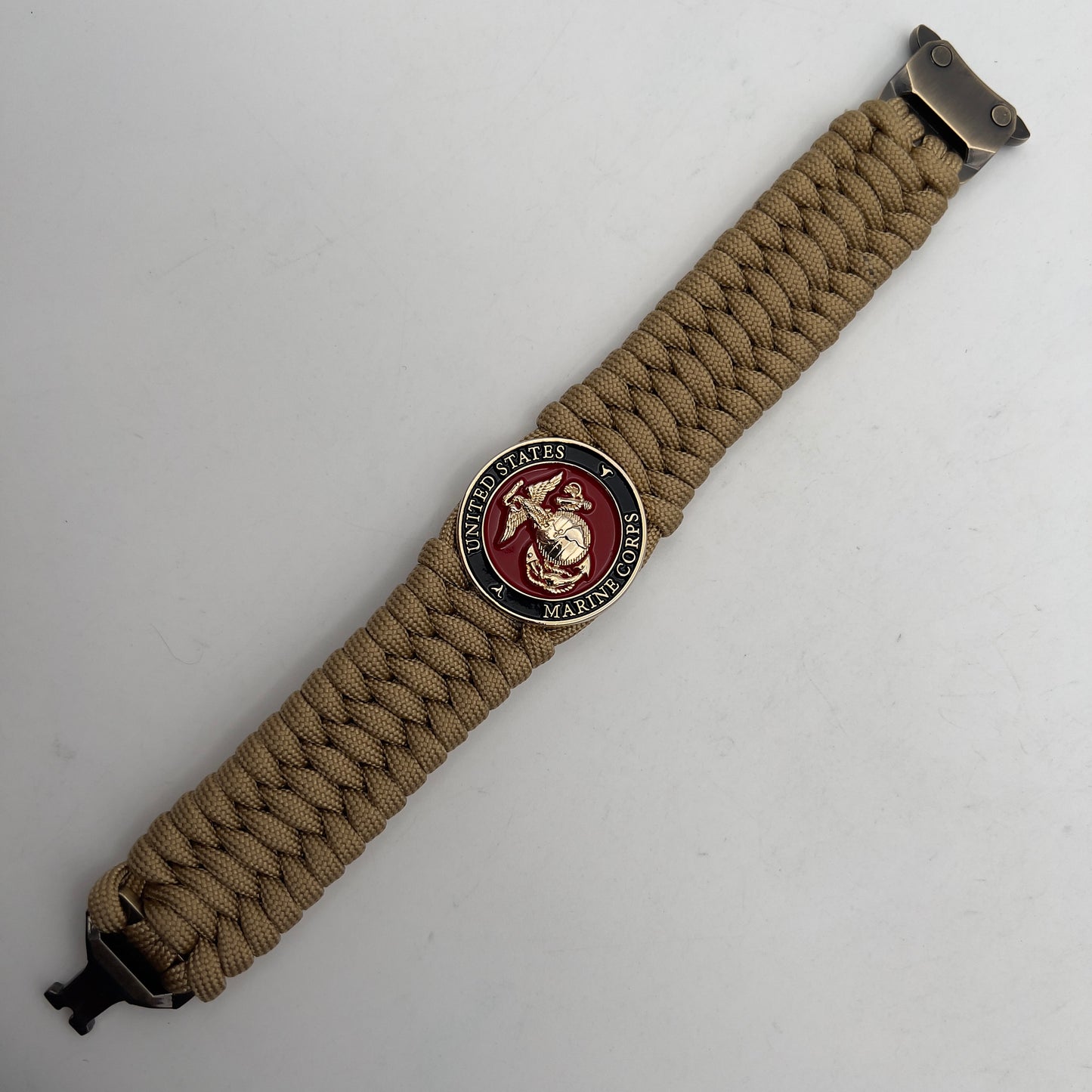 Thick, wide, rigid and comfortable braided United States Marine Corps bracelet featuring a 24K gold plated USMC Eagle Globe and Anchor medallion, a gold Cobra style tactical buckle and woven with gold 550 paracord.