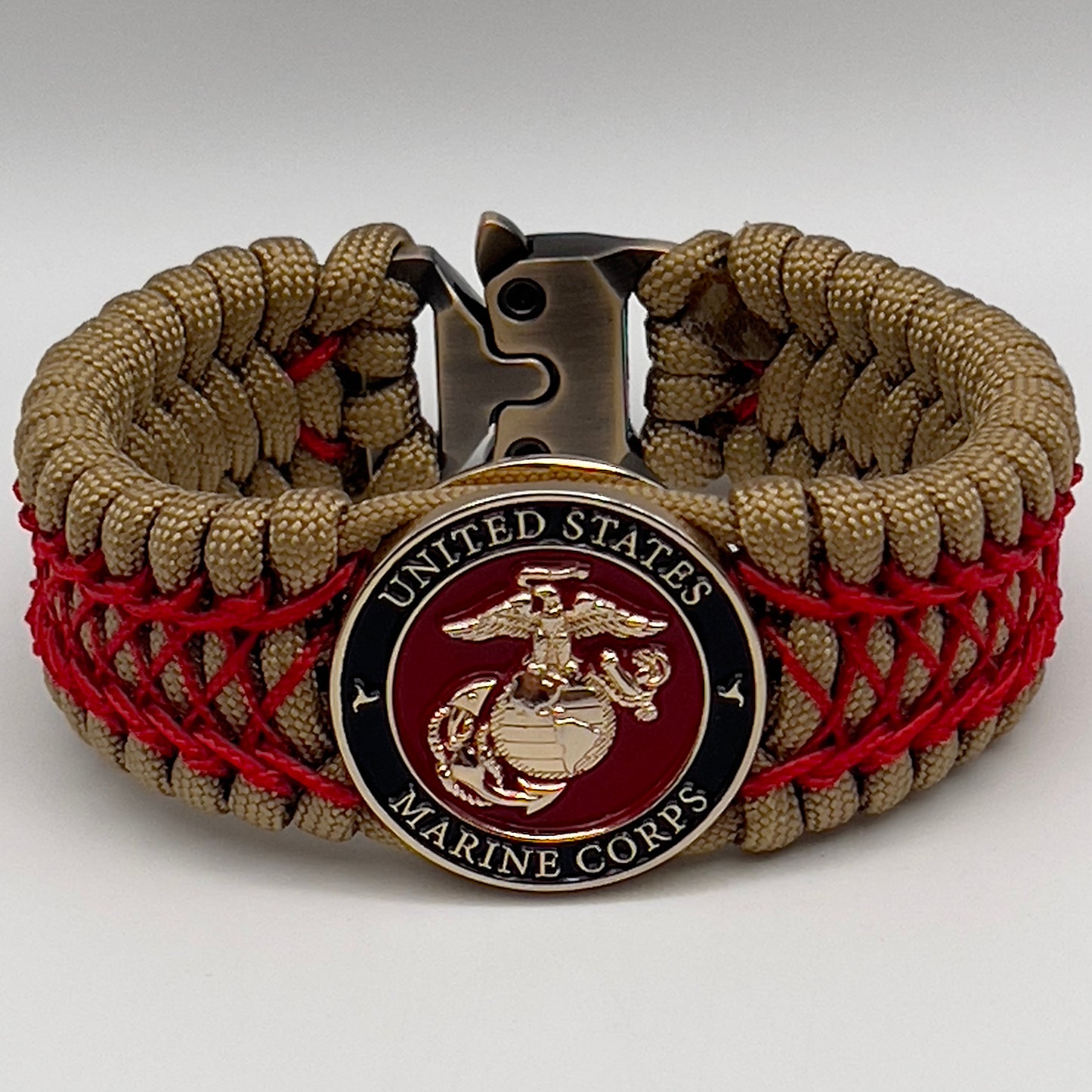 Thick, wide, rigid and comfortable braided United States Marine Corps bracelet featuring a 24K gold plated USMC Eagle Globe and Anchor medallion, a gold Cobra style tactical buckle and woven with gold 550 paracord and Imperial Red nano and micro cord.