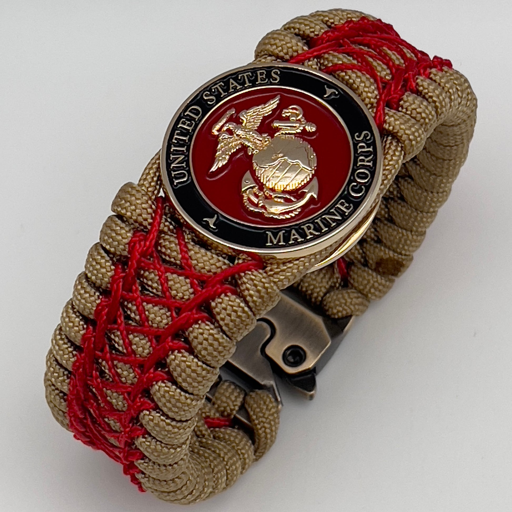 Thick, wide, rigid and comfortable braided United States Marine Corps bracelet featuring a 24K gold plated USMC Eagle Globe and Anchor medallion, a gold Cobra style tactical buckle and woven with gold 550 paracord and Imperial Red nano and micro cord.