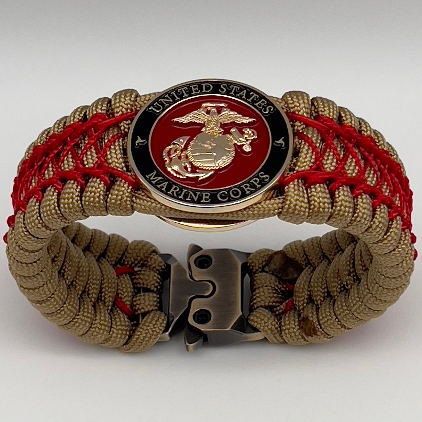 Thick, wide, rigid and comfortable braided United States Marine Corps bracelet featuring a 24K gold plated USMC Eagle Globe and Anchor medallion, a gold Cobra style tactical buckle and woven with gold 550 paracord and Imperial Red nano and micro cord.
